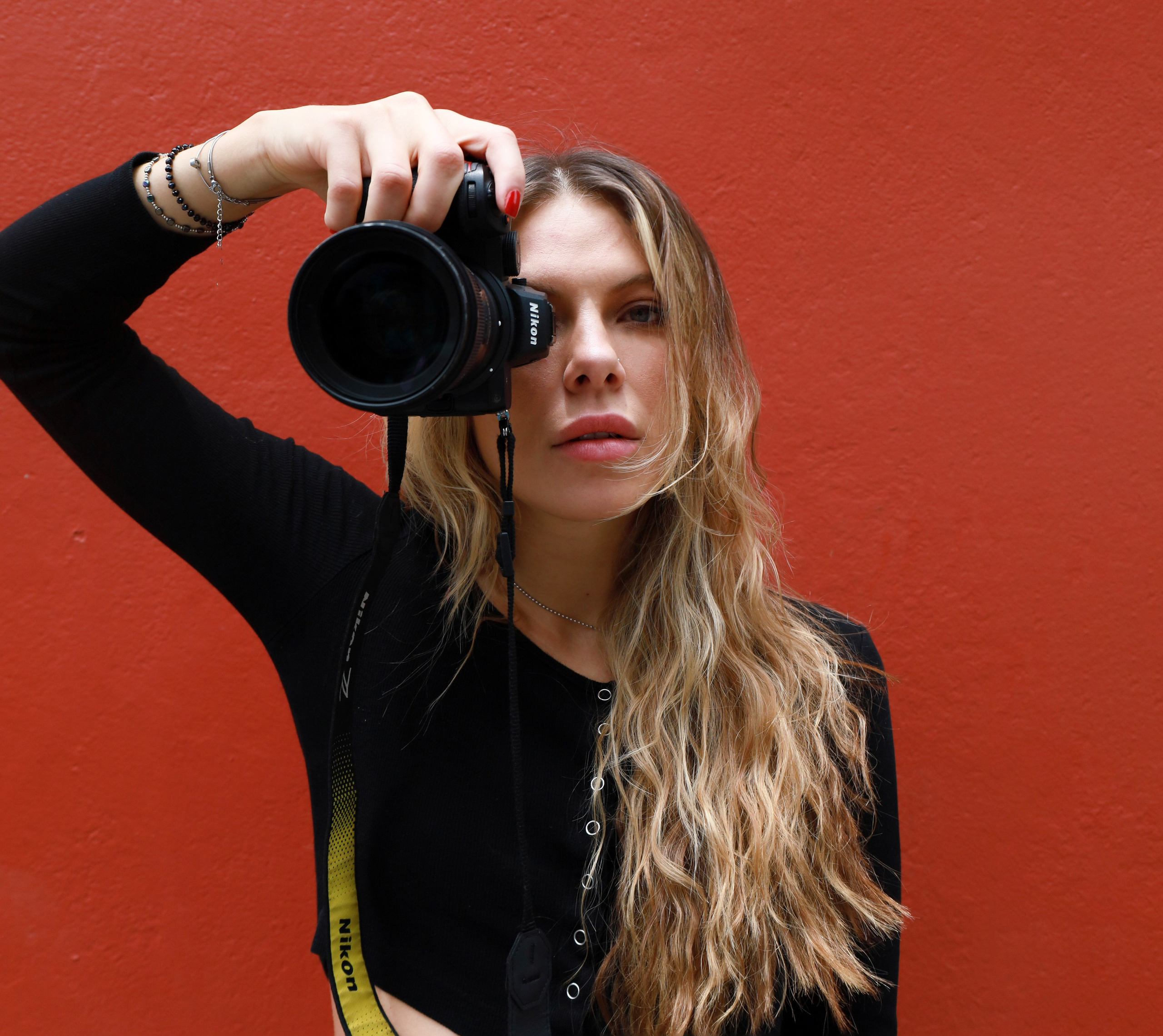 Dasha fotógrafa profesional, sosteniendo su cámara mientras se prepara para capturar momentos especiales en la Ciudad de México.