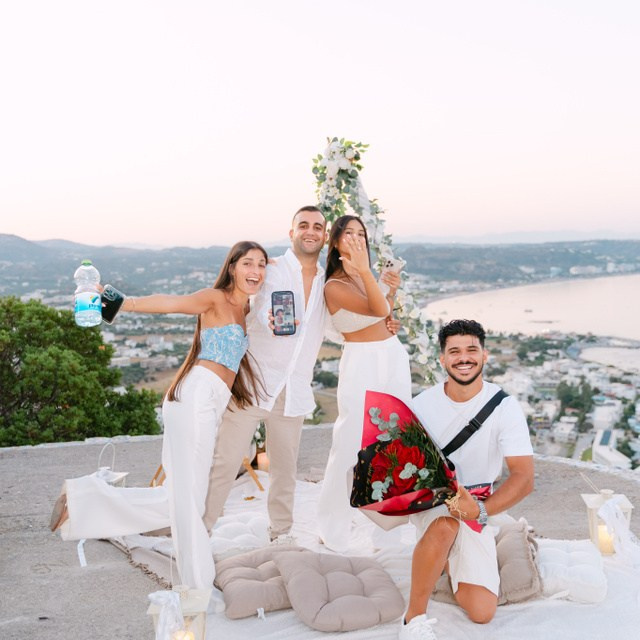 Engagement in Rhodes 💍 engaged couple sitting after the proposal at Profitis Ilias near Faliraki overlooking the Aegean Sea in Greece.