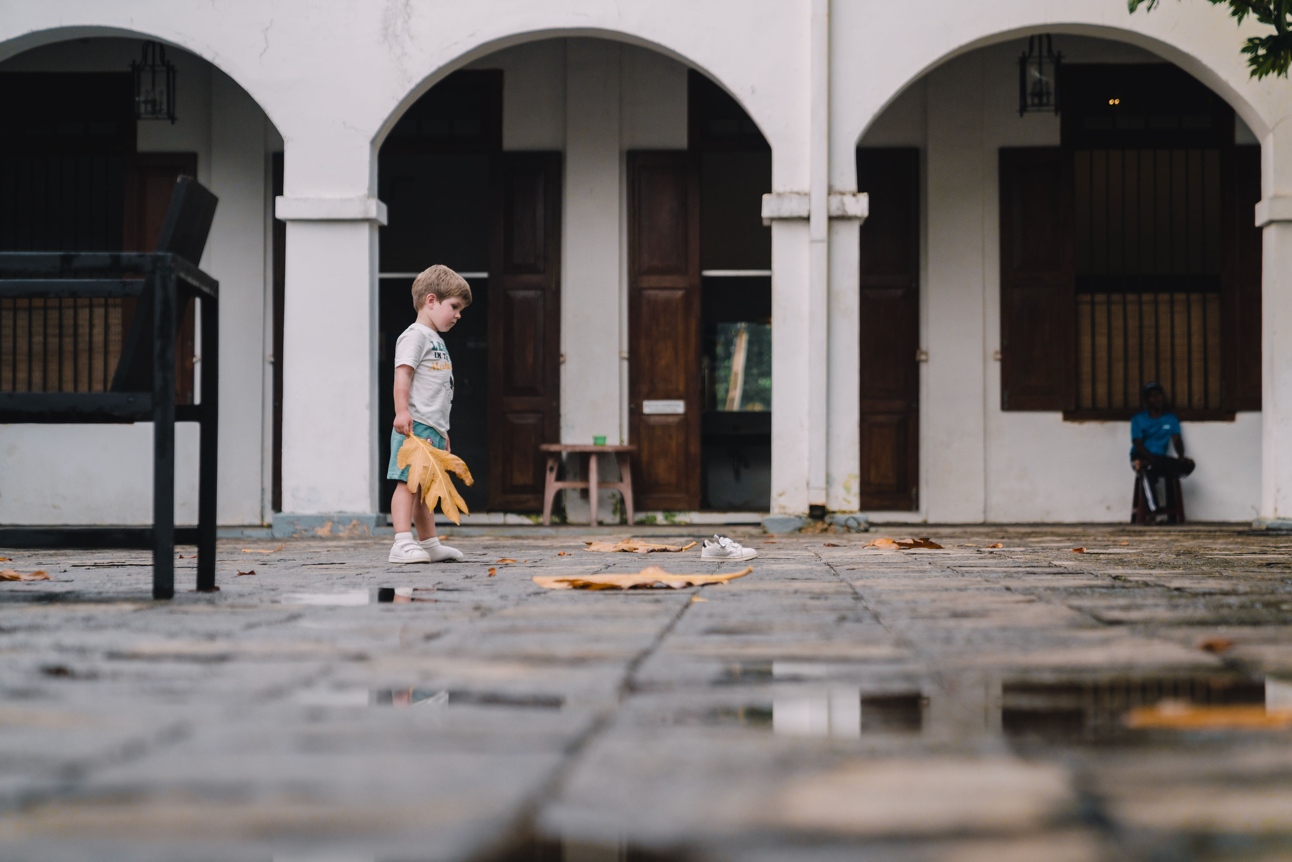A photo of funny kid who lost his shoe and looking for it