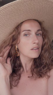 A woman thoughtfully looks at the camera with a large ring – color portrait, photography