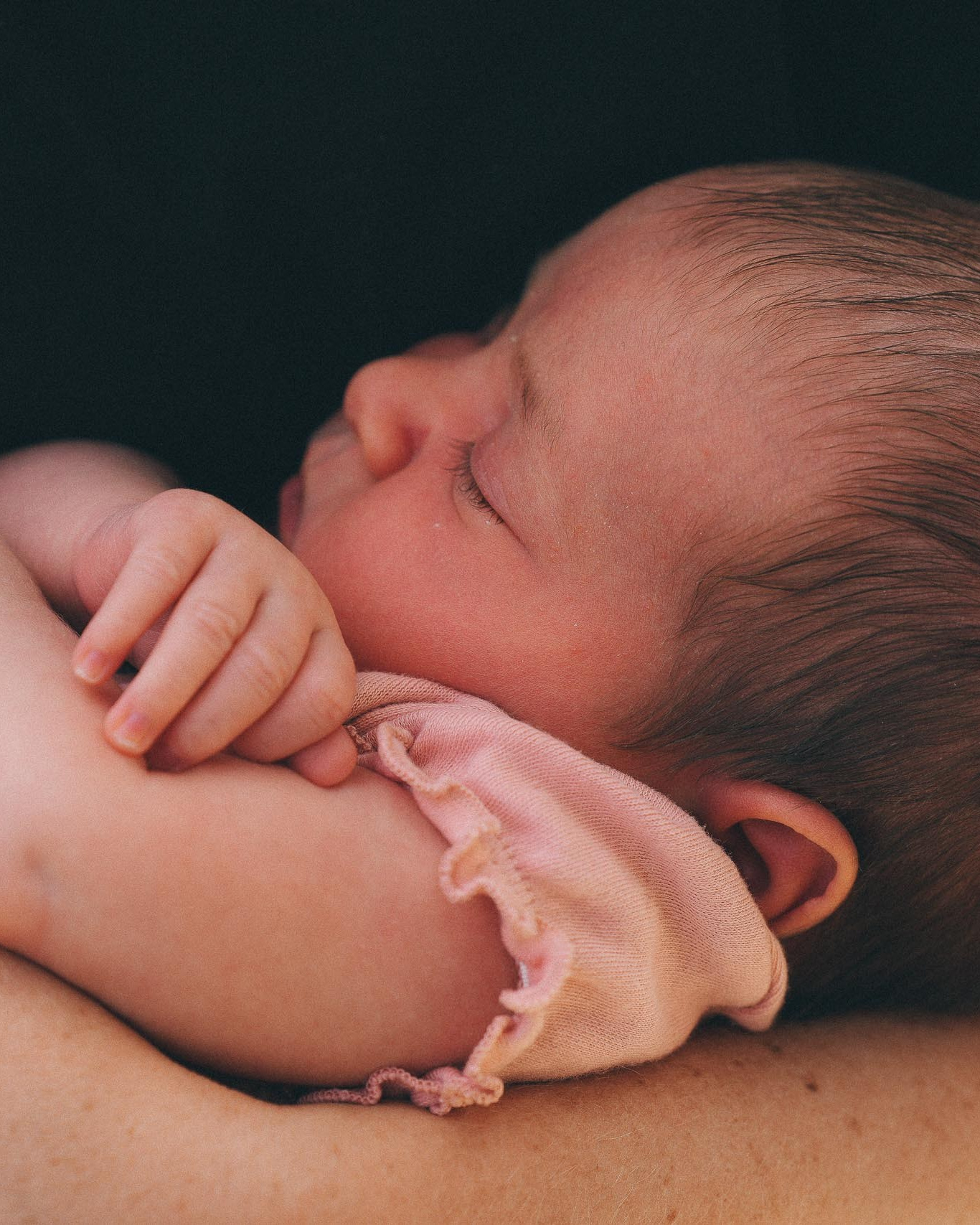 Parents holding their newborn baby during a calm lifestyle newborn photography session at home in Solihull