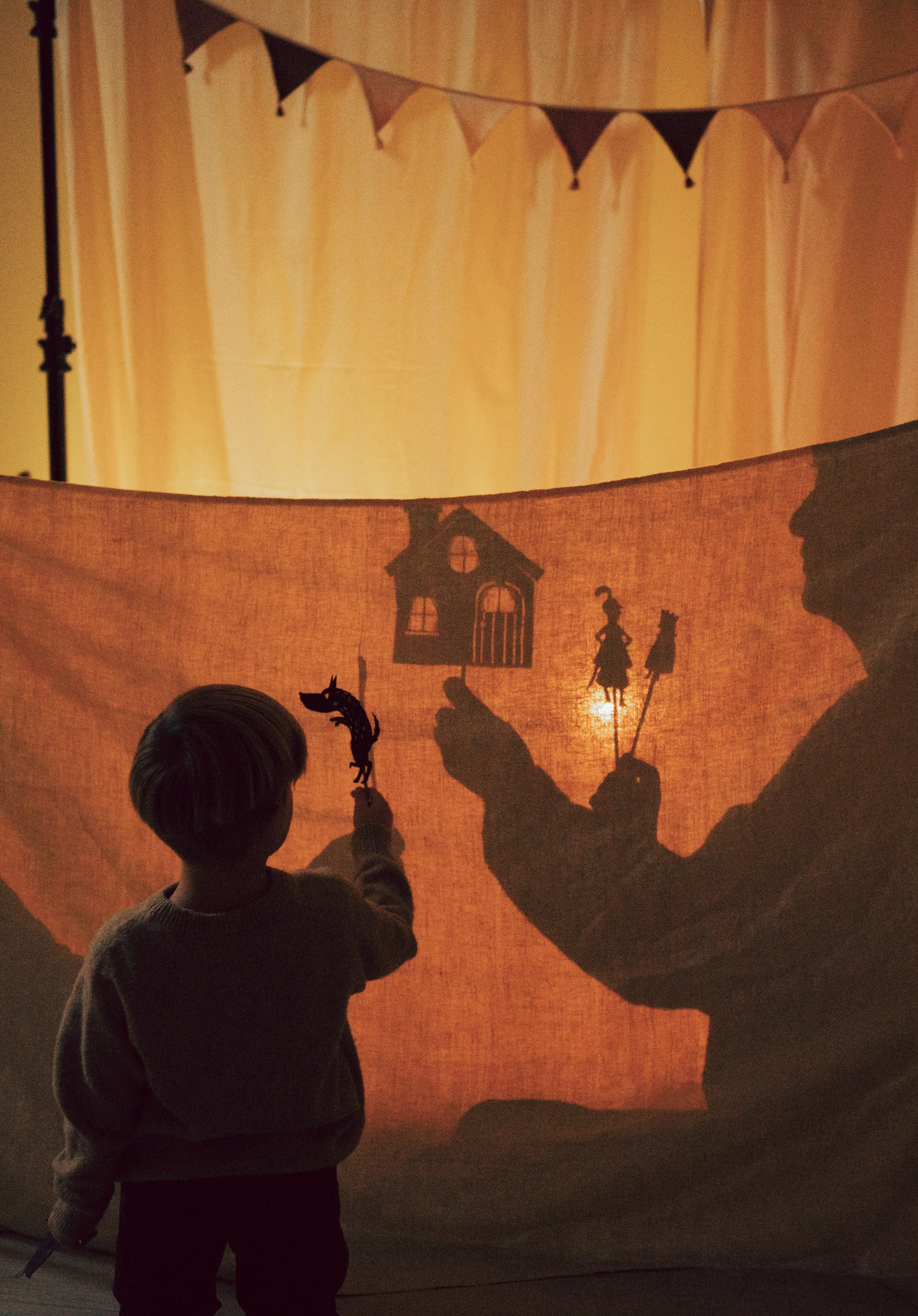 Un momento familiare pieno di poesia: genitori e bambino danno vita a un teatrino delle ombre dietro un telo illuminato da una luce calda. Le sagome fatte a mano, l’atmosfera invernale e i dettagli natalizi trasformano questa scena in un ricordo intimo e creativo da custodire. sservizio fotografico natalizio famiglia, teatrino delle ombre, gioco creativo bambini, atmosfera intima natalizia, luce calda inverno, fotografia di famiglia creativa, racconti di Natale, connessione genitori figli, pupazzi fatti a mano, anastasiia buchinskaia photographer, anamilanofoto