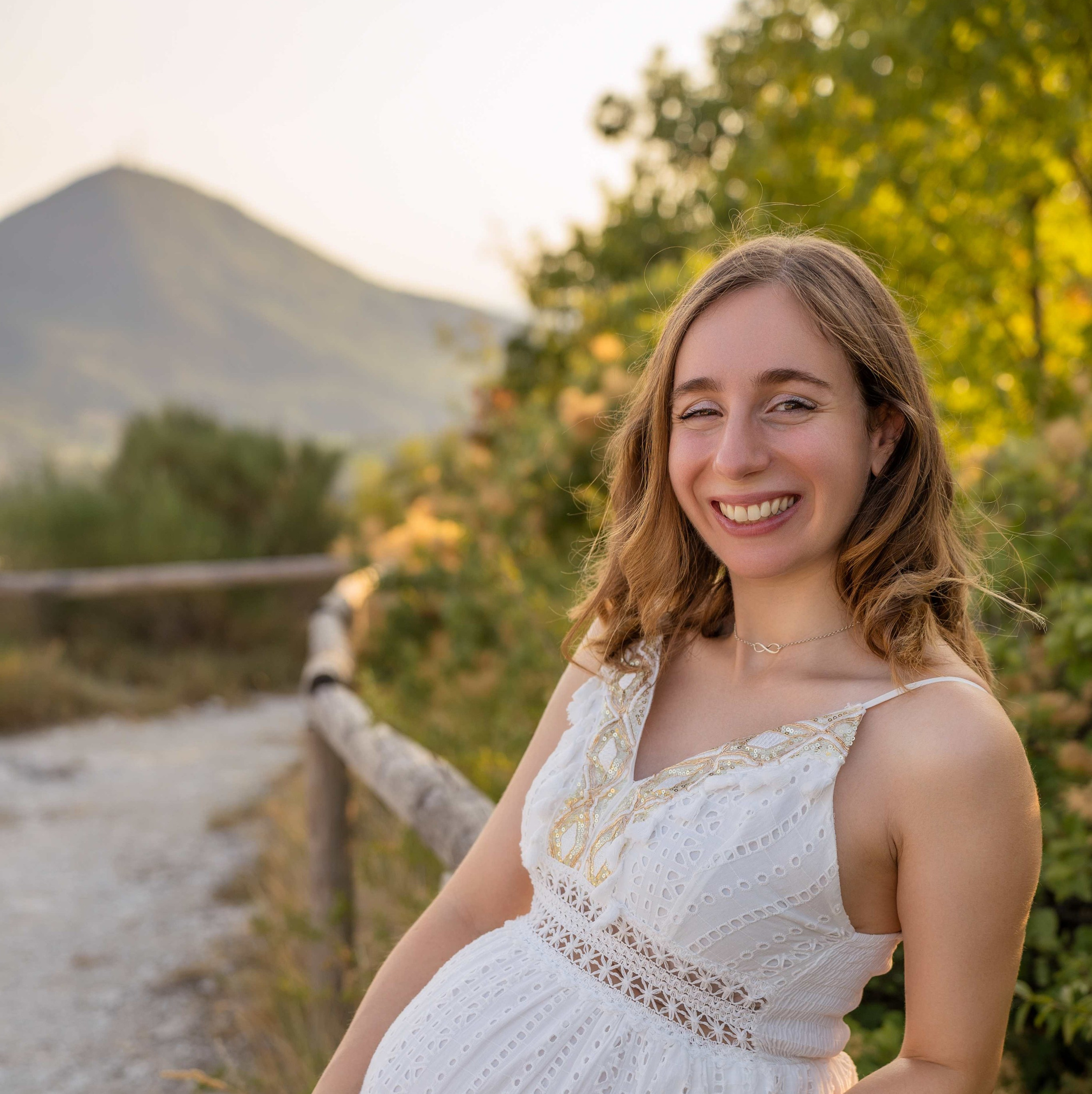 Futura mamma in abito bianco durante un servizio fotografico di gravidanza sui Colli Euganei