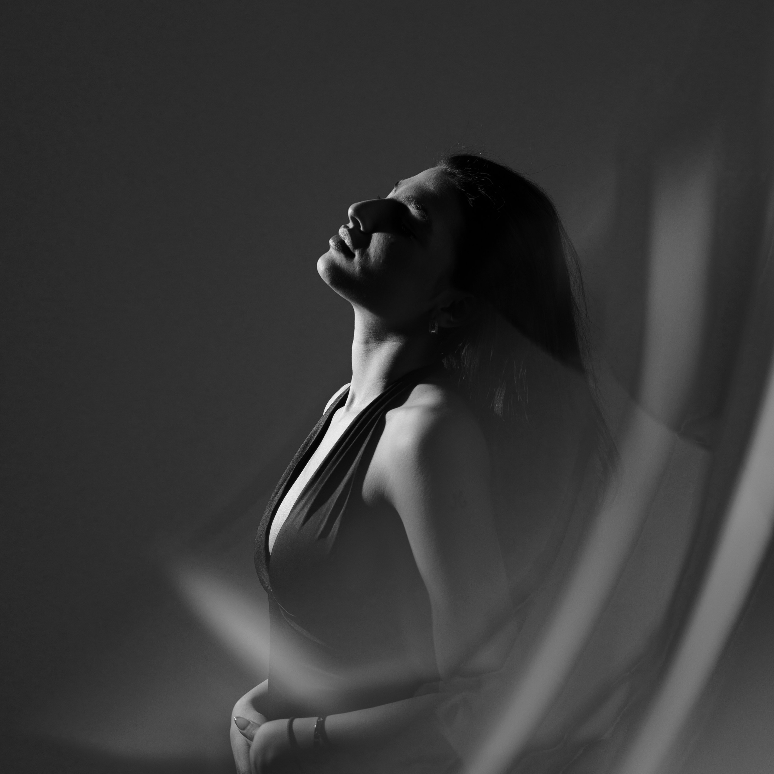 Художественный черно-белый портрет женщины в мягком свете, момент тишины