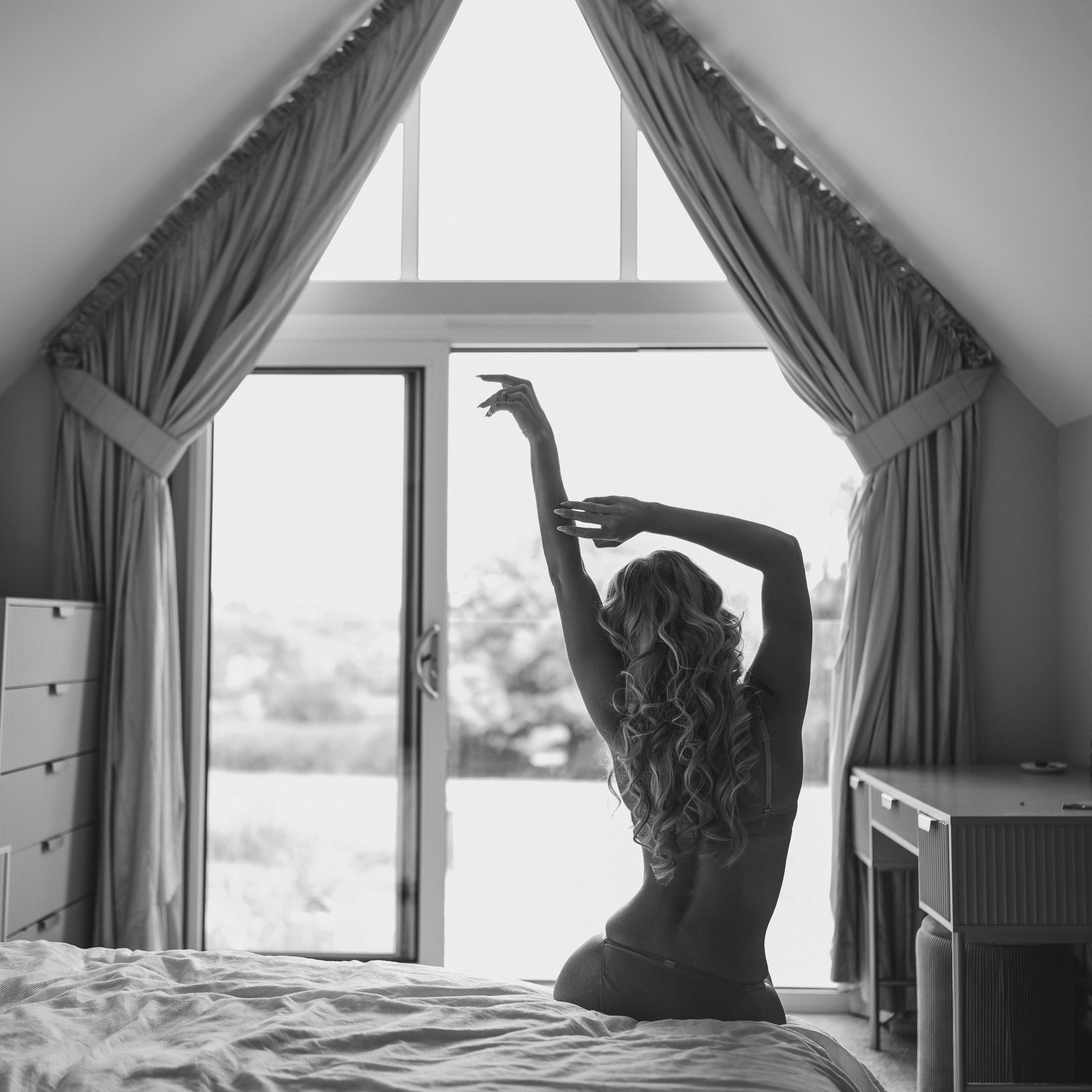 Woman posing in natural light during a boudoir photography session in Solihull