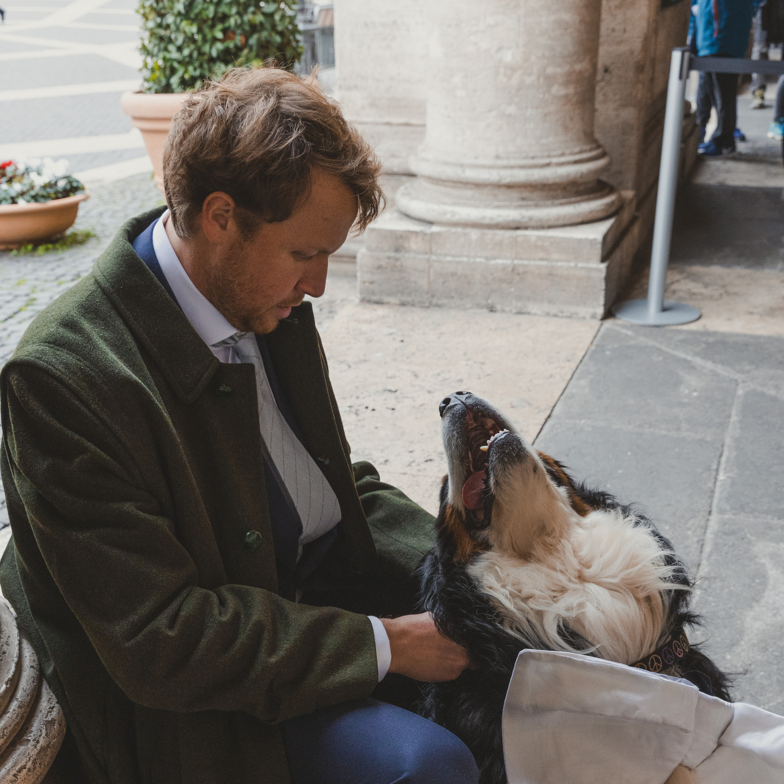 A portrait photography of a groom getting ready for her perfect luxurious destination wedding in Rome with his dog.