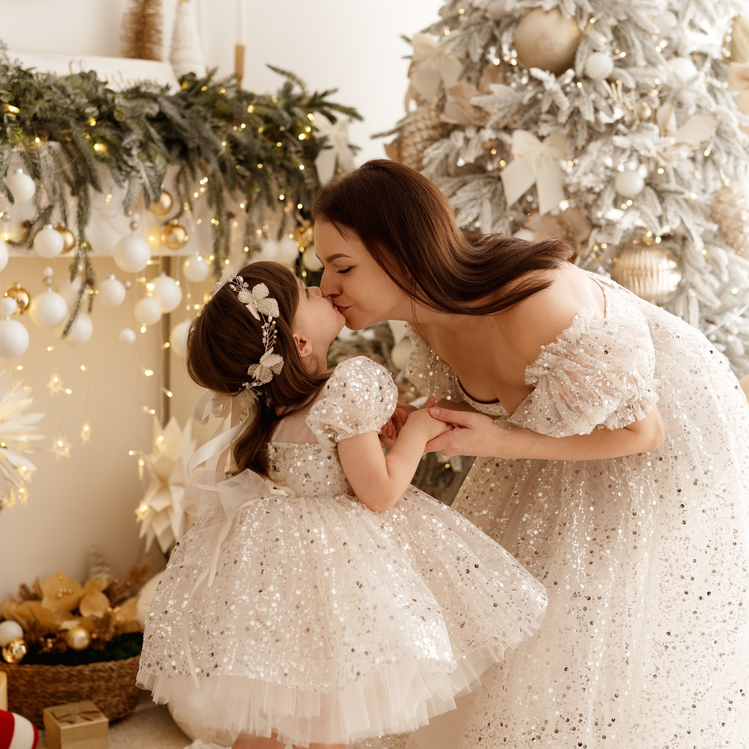 Sesje świąteczne w Łodzi – dzieci w białych strojach tańczące wokół choinki