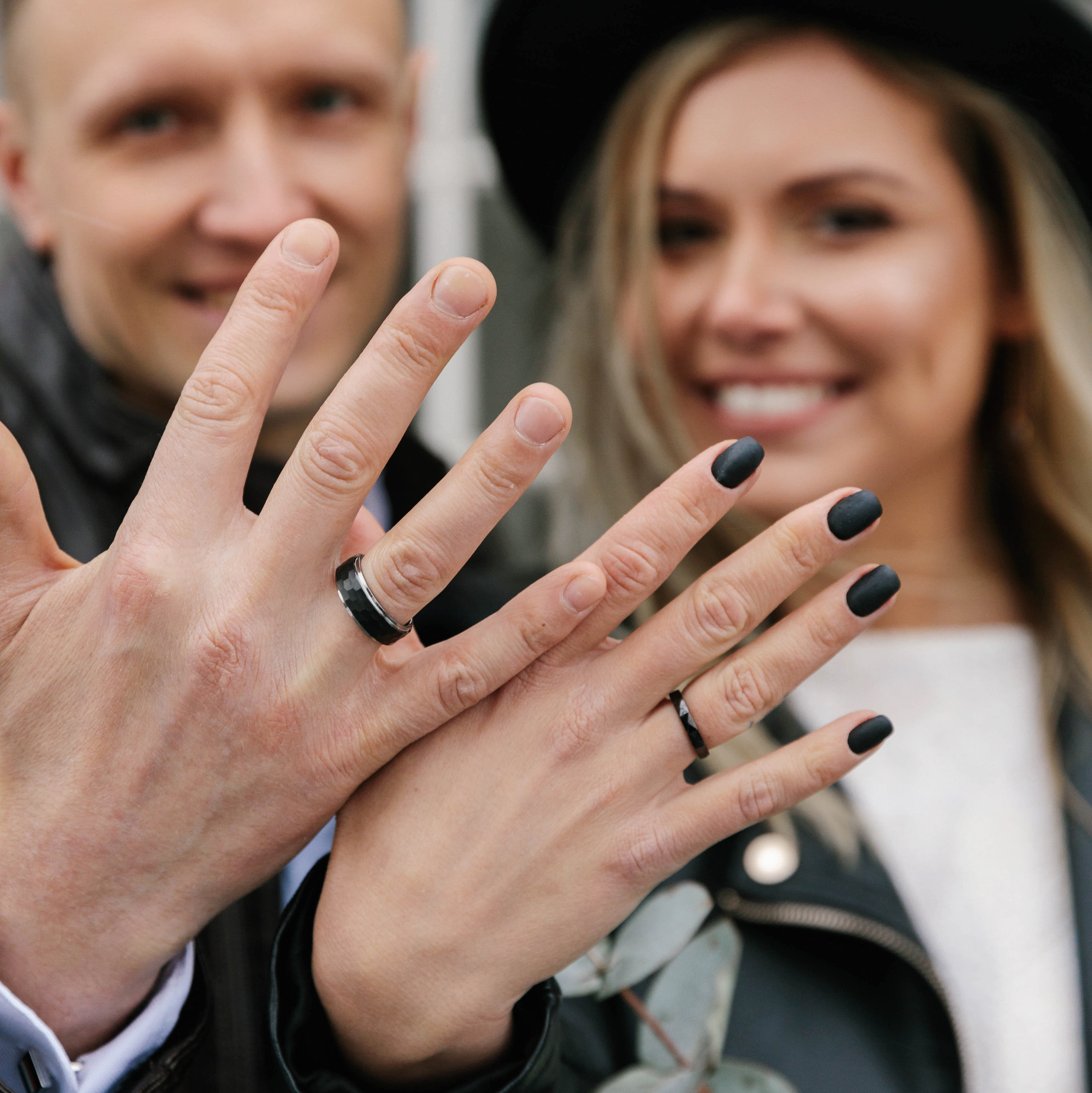 The bride and groom show wedding rings near the registry office in Tallinn