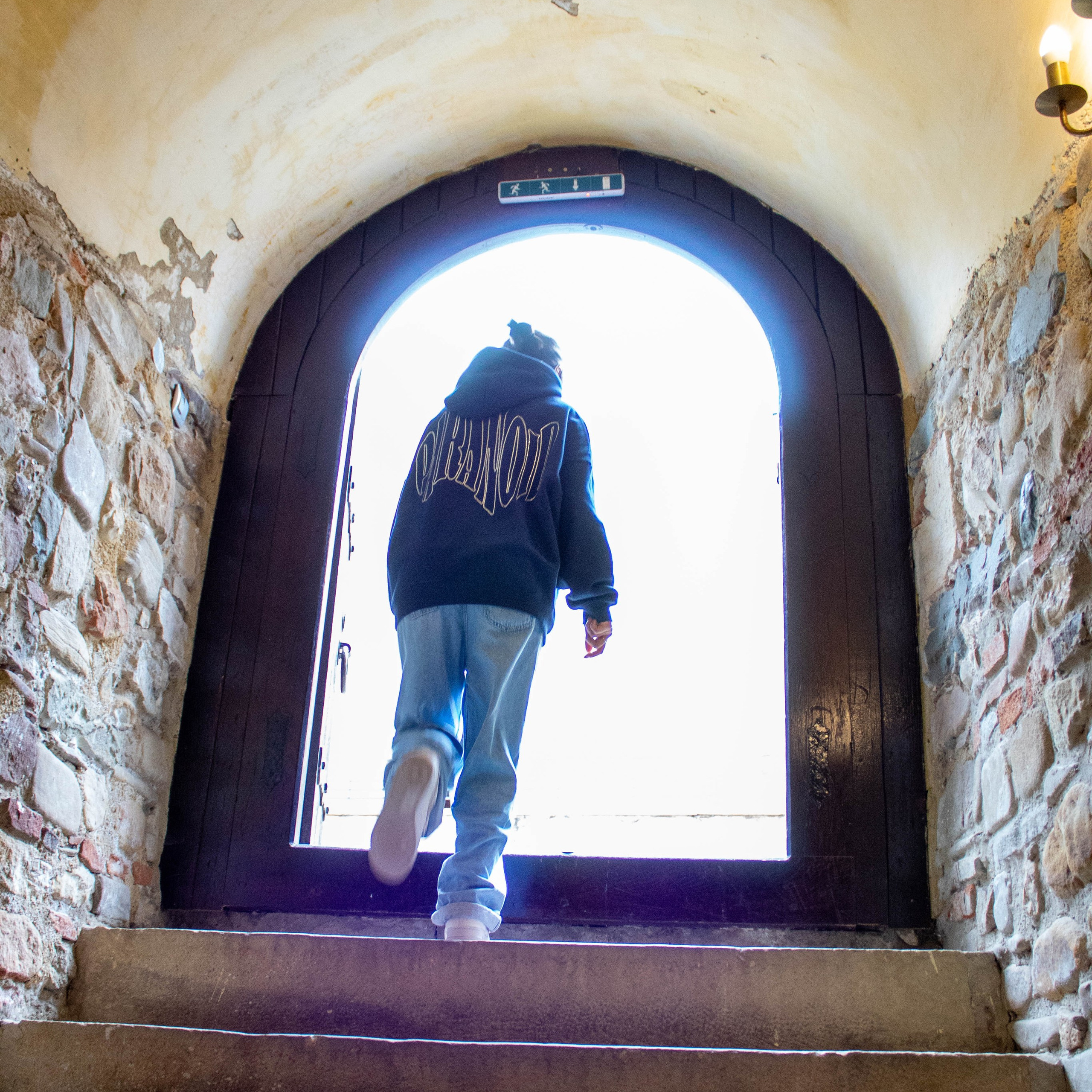 Stone corridor with a glowing blue and pink arched doorway