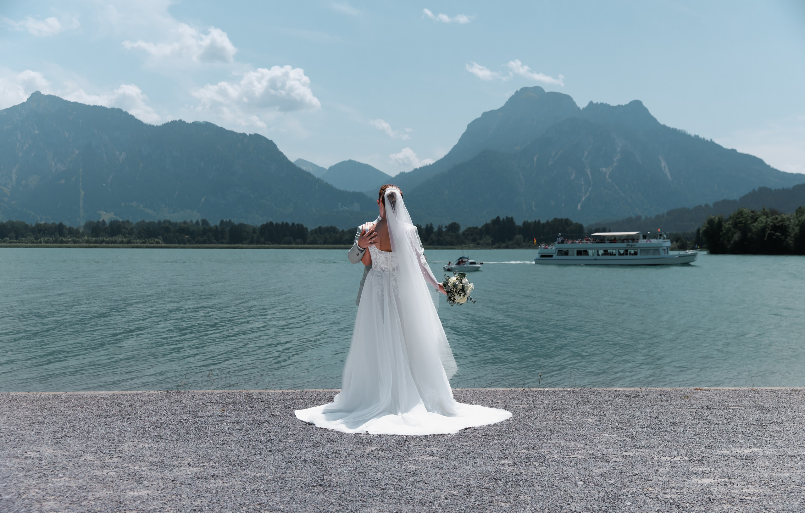 alt="Romantisches Brautpaar in Füssen mit Alpenpanorama im Hintergrund"