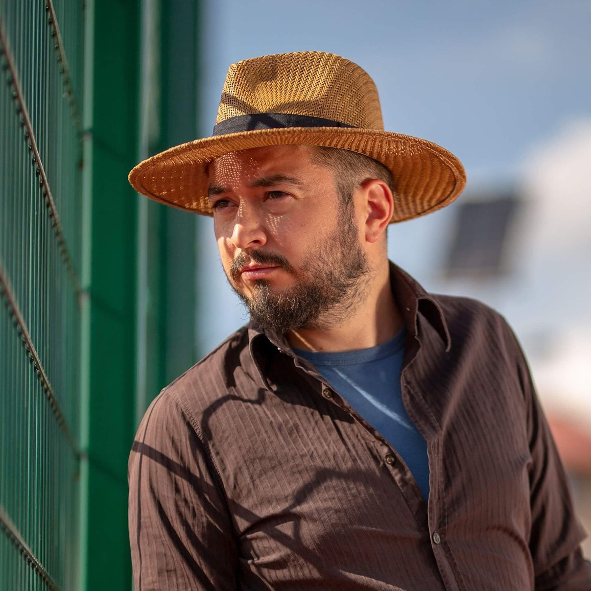 Portret profesional al fotografului Alex Vasilie, surprins într-un cadru natural și luminos, reprezentând stilul artistic și personalitatea acestuia.