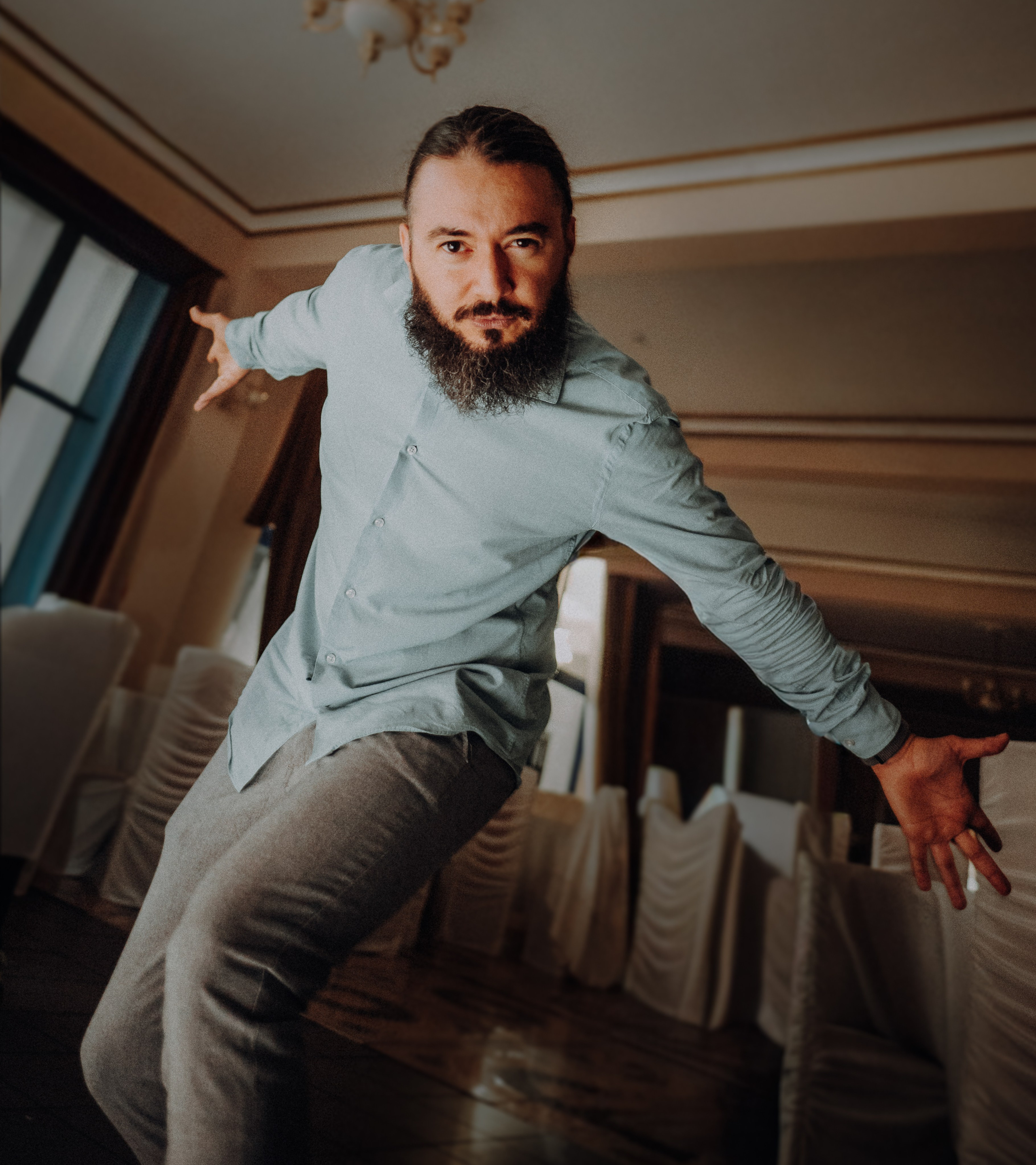 Portret profesional al fotografului Alex Vasilie, surprins într-un cadru natural și luminos, reprezentând stilul artistic și personalitatea acestuia.