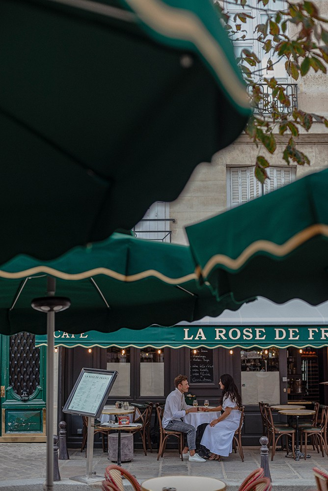 A couple celebrating their engagement at Parisian Café on Place Dauphine