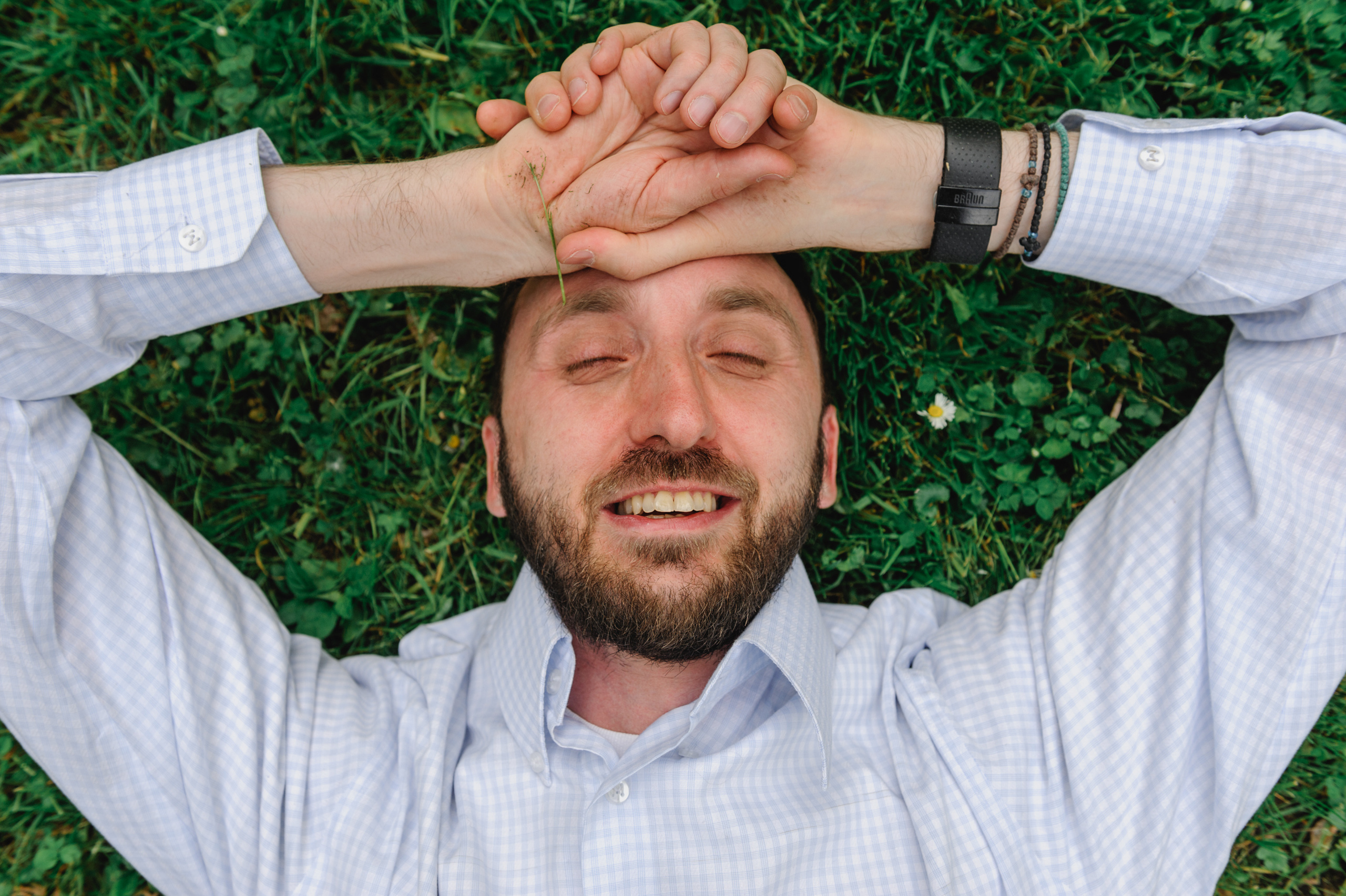 Art historian and cultural scholar Dmitry Solodkiy lying on the grass with closed eyes, enjoying himself.