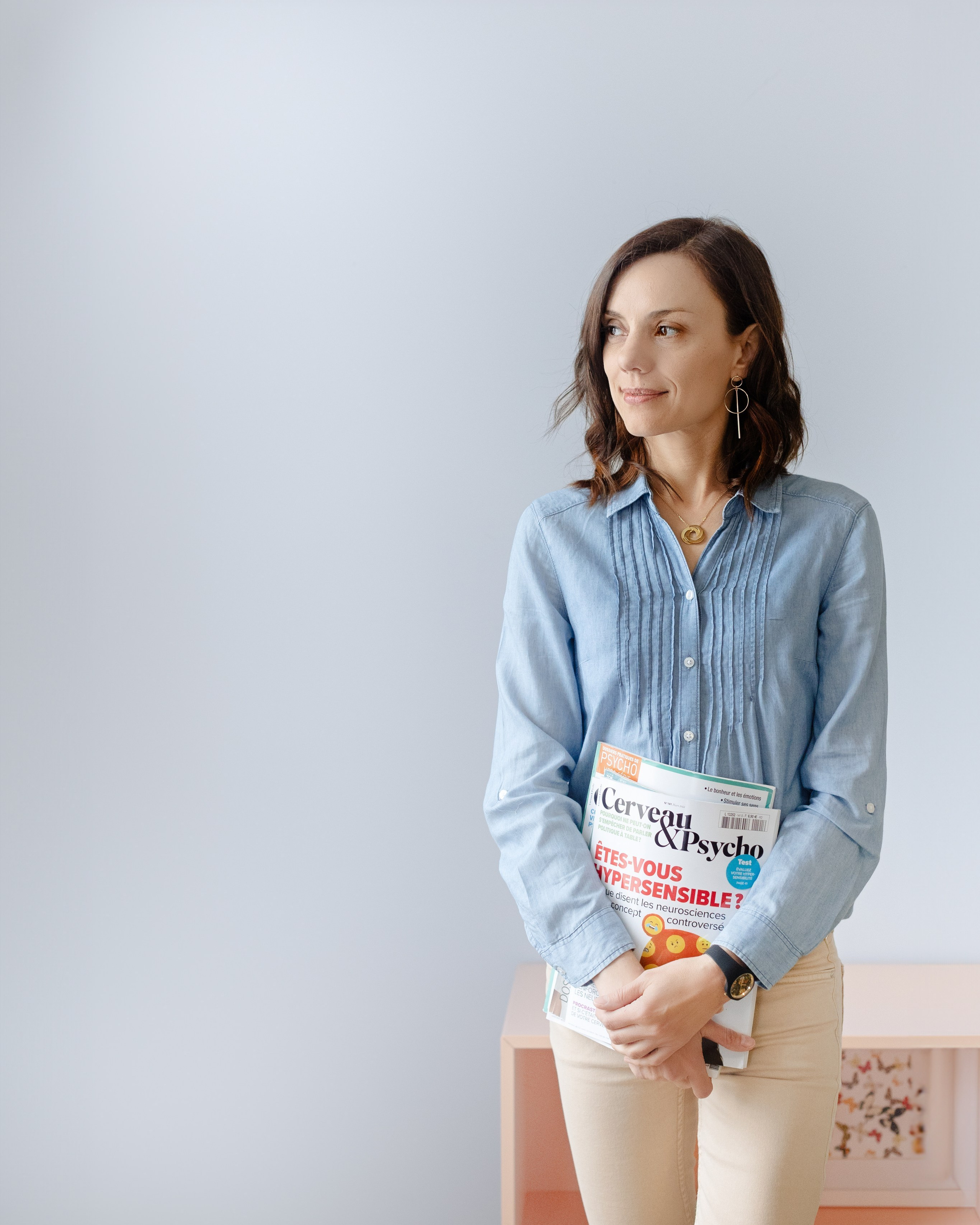 personal branding portrait of a female entrepreneur holding a magazine in a bright studio