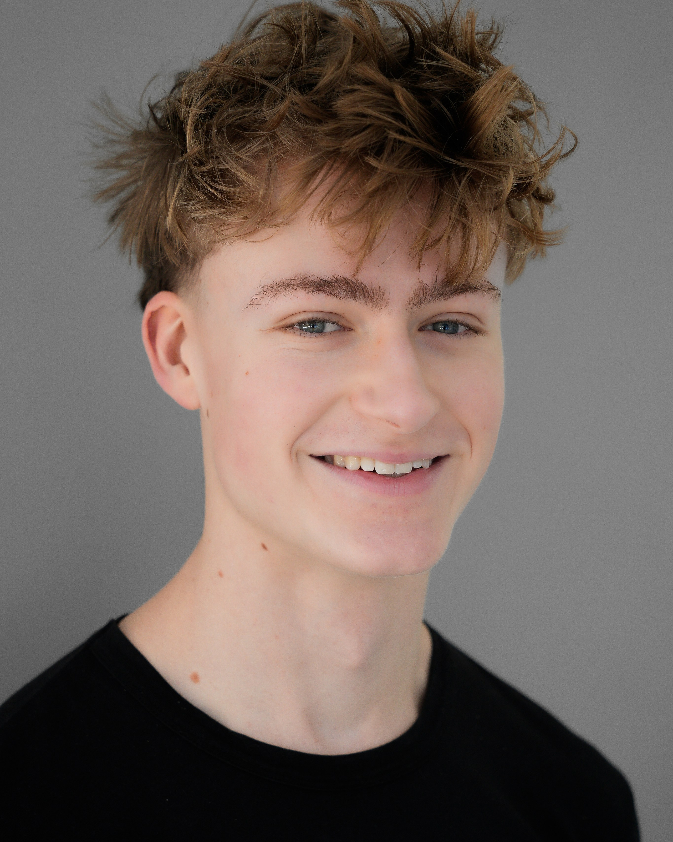Clean studio headshot of a young actor with natural expression, photographed in soft light in Solihull.