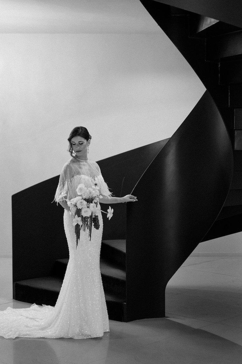 Editorial black and white bridal portrait beside a sculptural staircase at a real wedding in Portugal