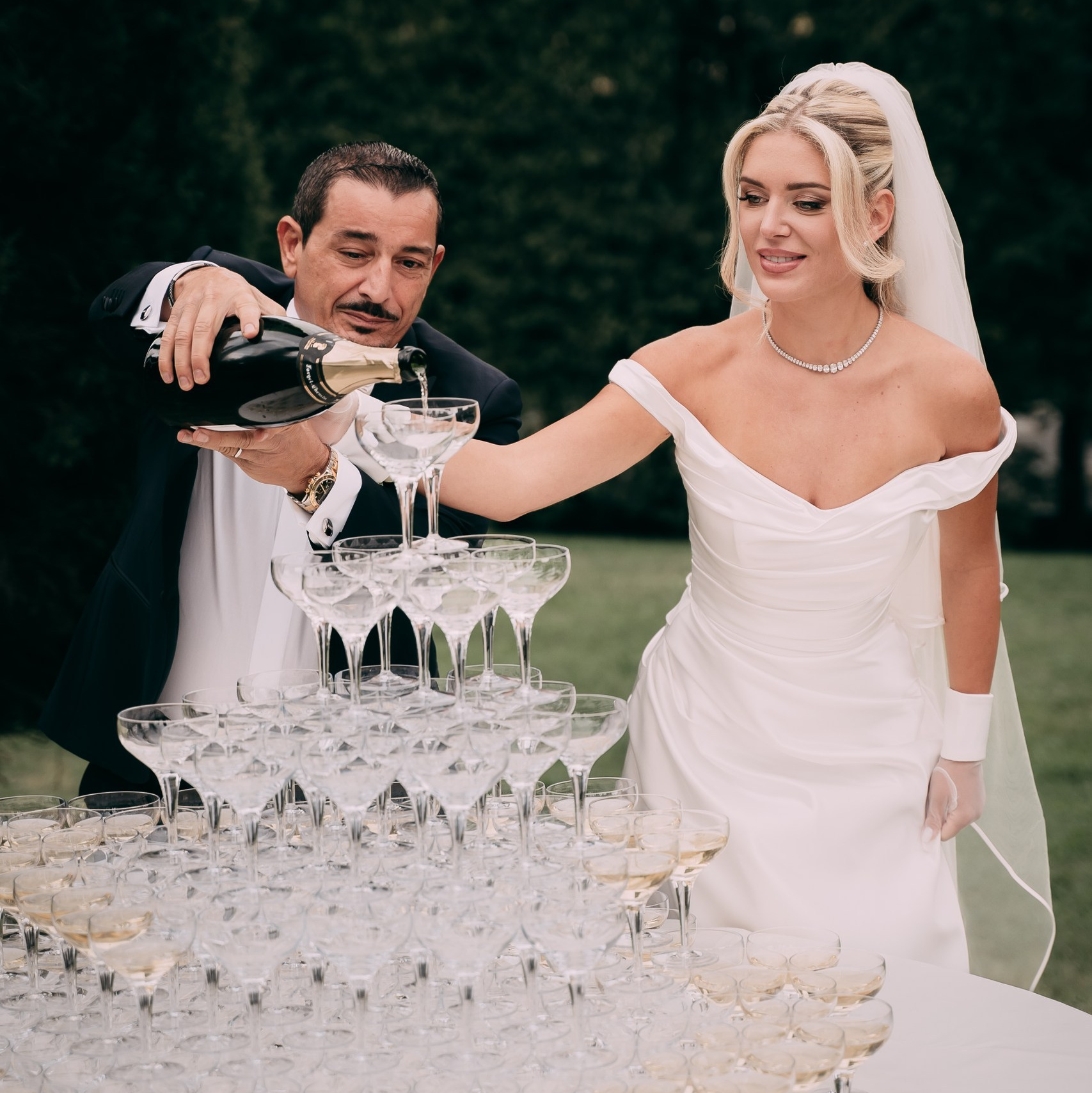 Sposi versano champagne durante il ricevimento – fotografia elegante di matrimonio in Italia
