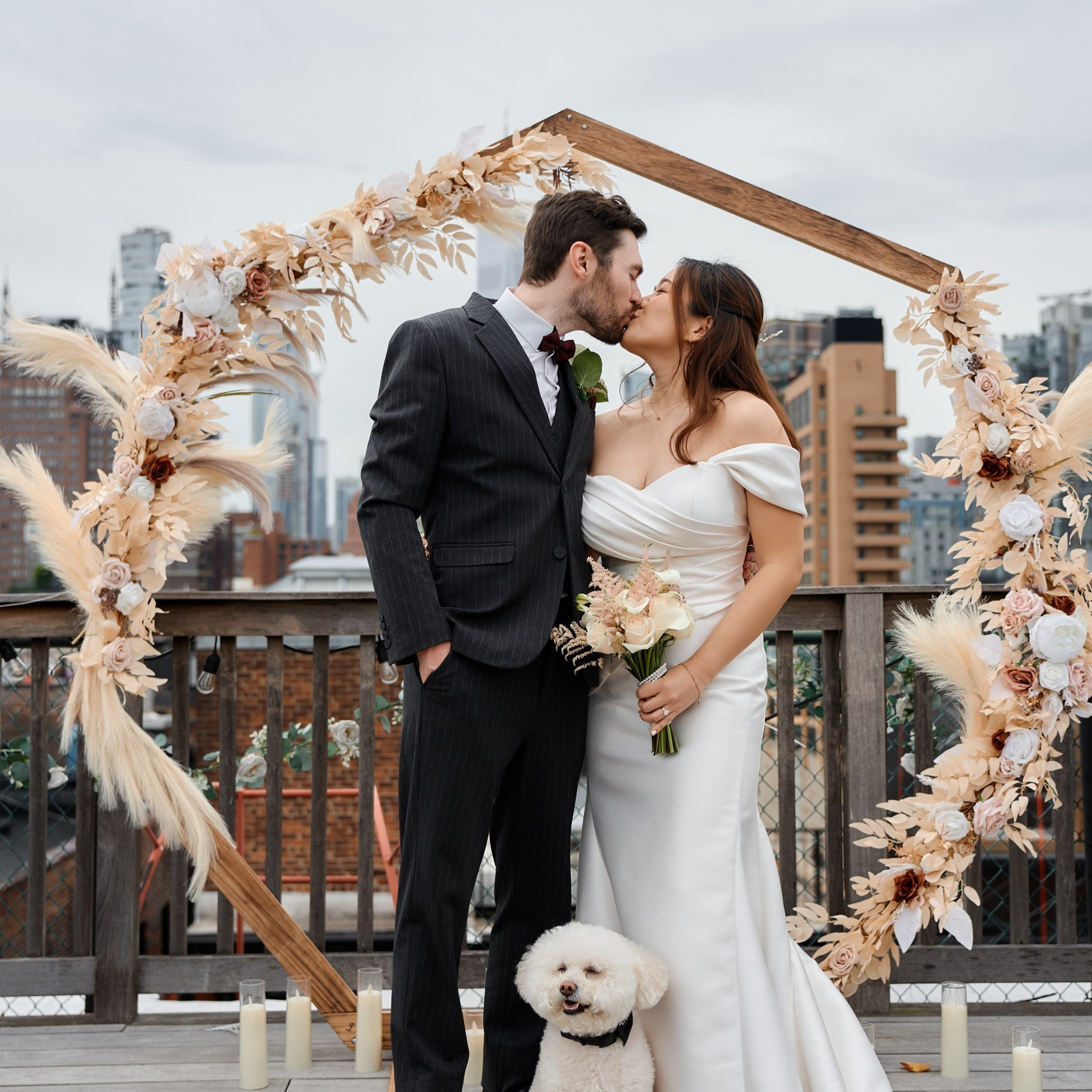 Bride and groom with dog at outdoor wedding ceremony arch in New York