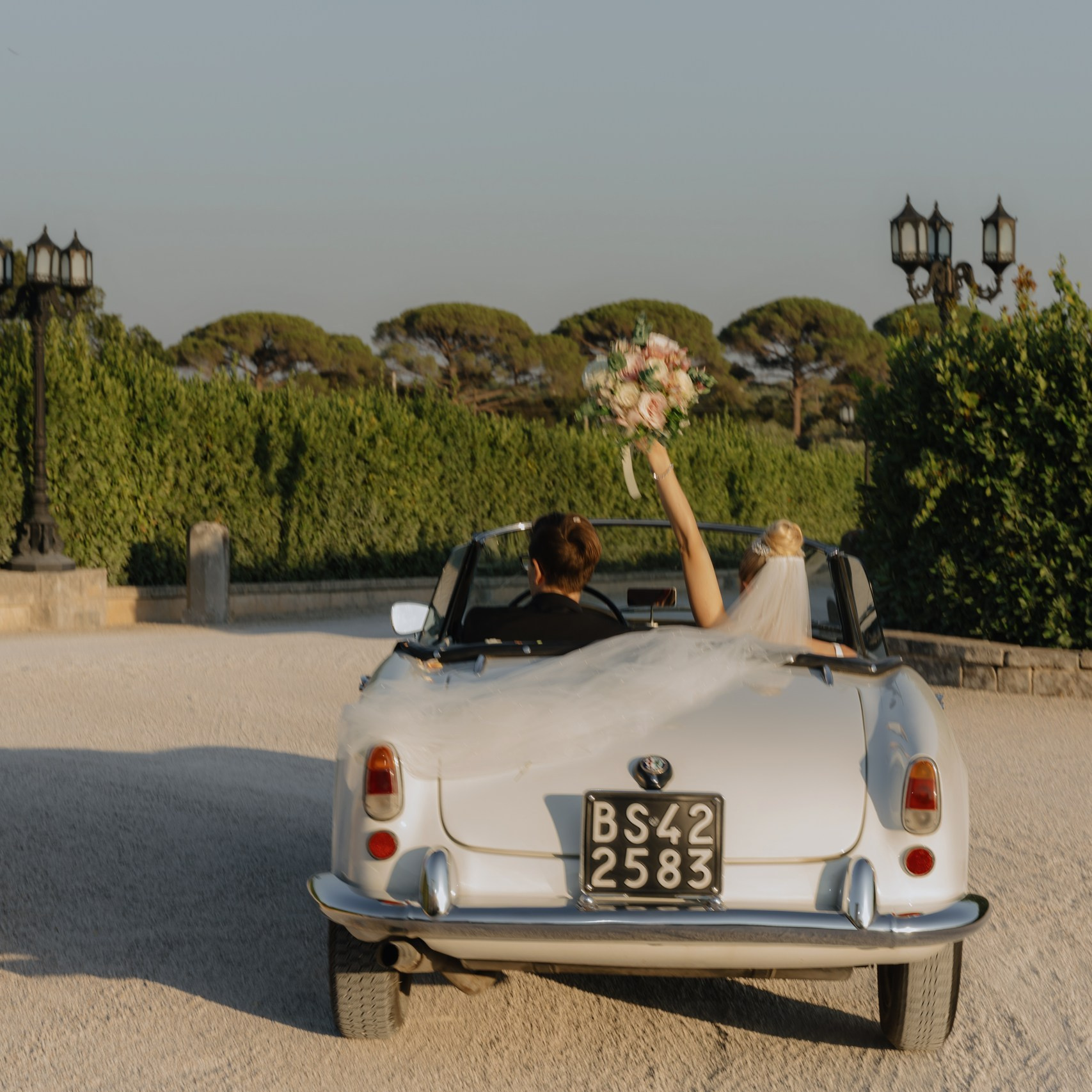 Couple driving vintage car in Italy countryside, editorial style wedding photography