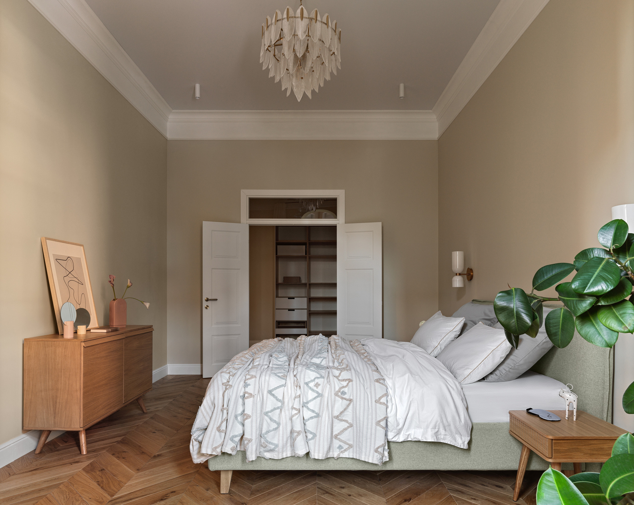 Спальня с акцентной стеной, винтажным комодом и большим зеркалом в резной раме.