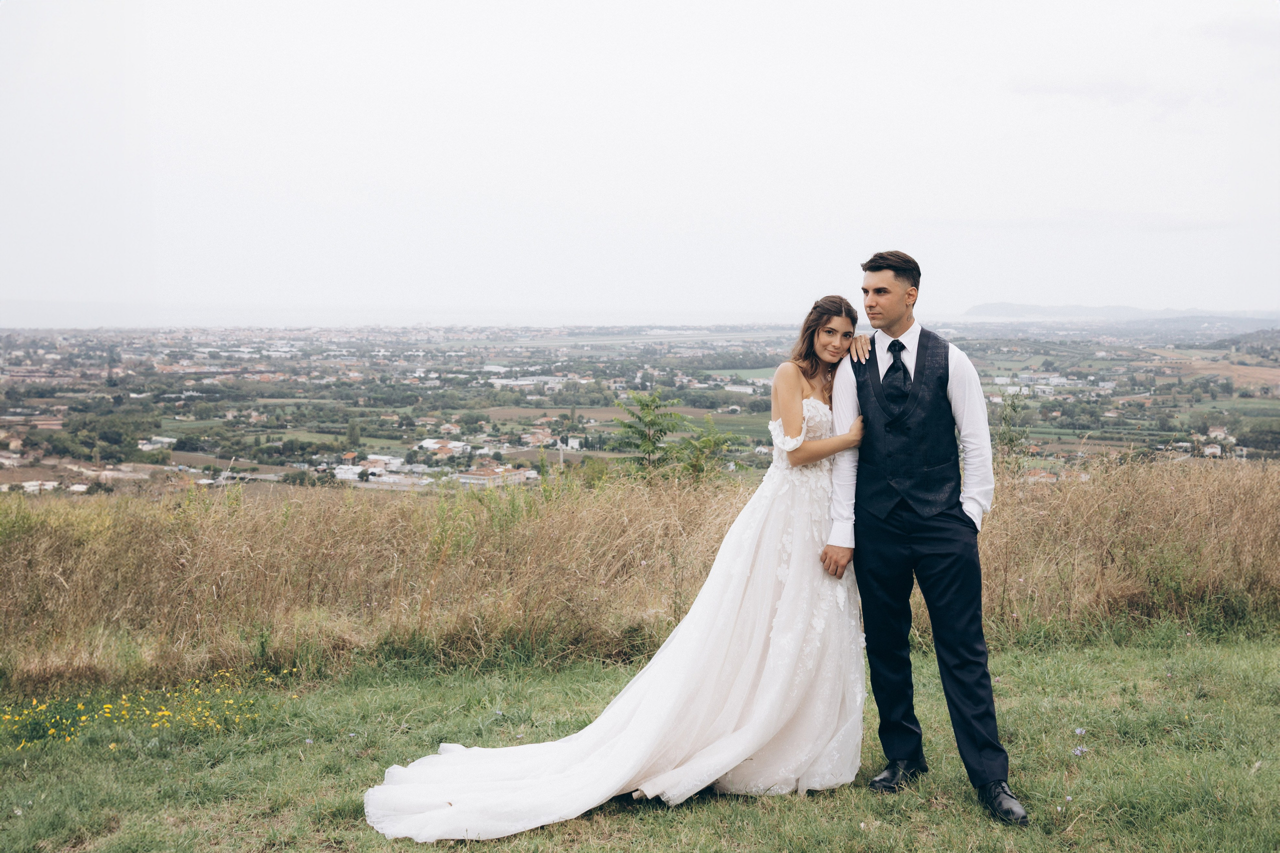 Coppia di sposi in un paesaggio aperto, un matrimonio vissuto con calma, naturalezza e attenzione al ritmo della giornata