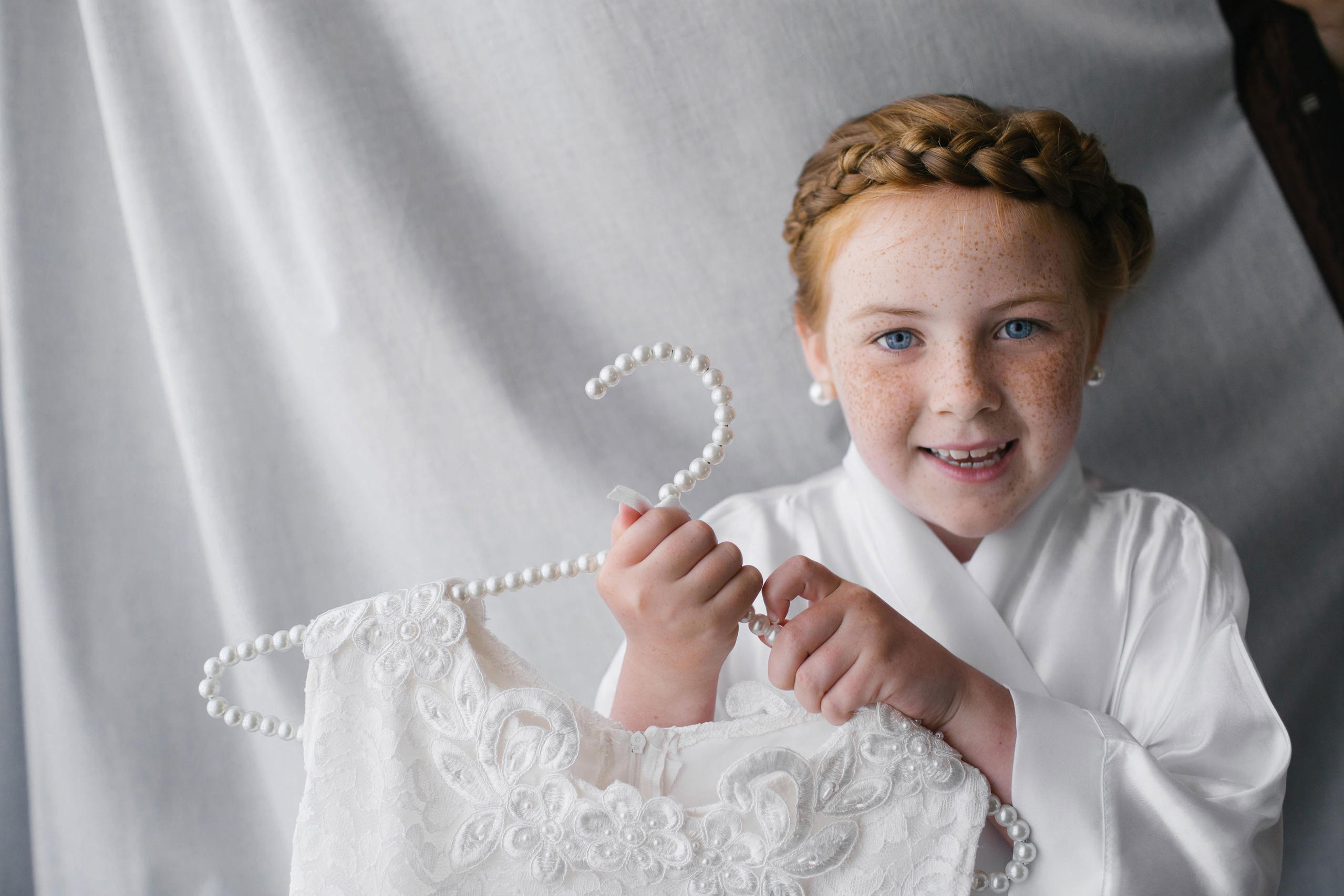 Red haired girl holding a white dress