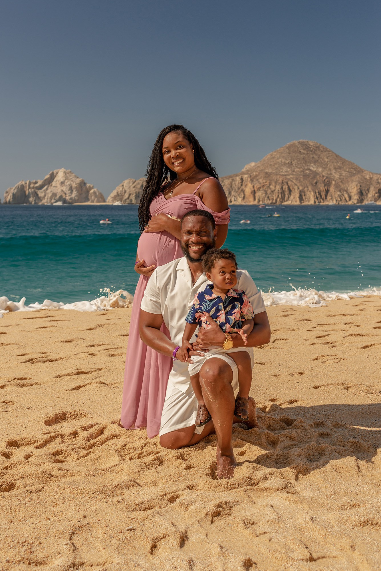 Maternity session on a Cabo beach, mom in a blush dress and dad in white