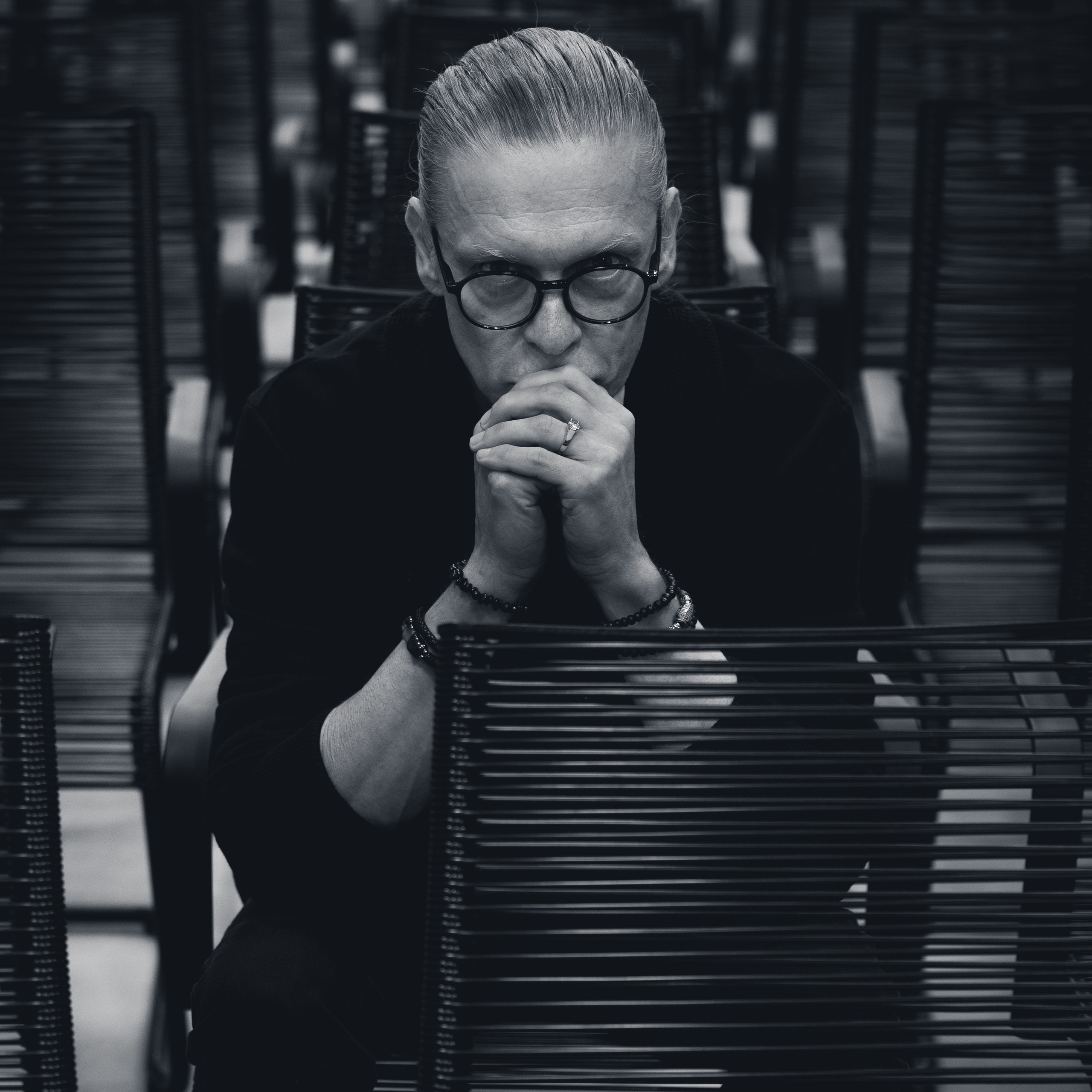Портрет (ч/б, мужчина в очках, руки у лица)Описание: Портрет с характеромALT: Чёрно-белый мужской портрет в студийном стиле — фотограф Сергей Трифонов, Вильнюс / Каунас, Литва