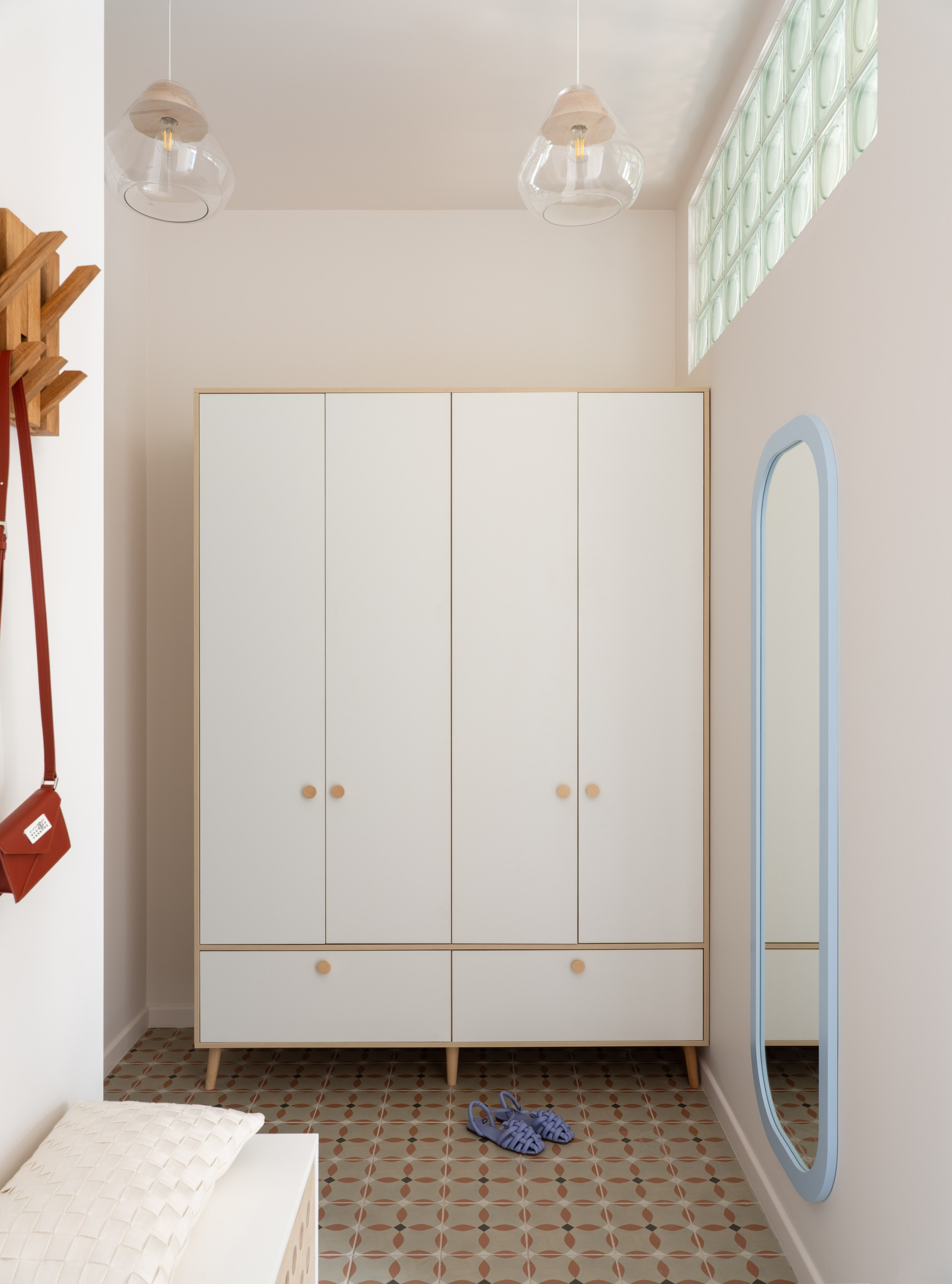 Интерьер прихожей с большим шкафом на ножках и окном из стеклоблоков