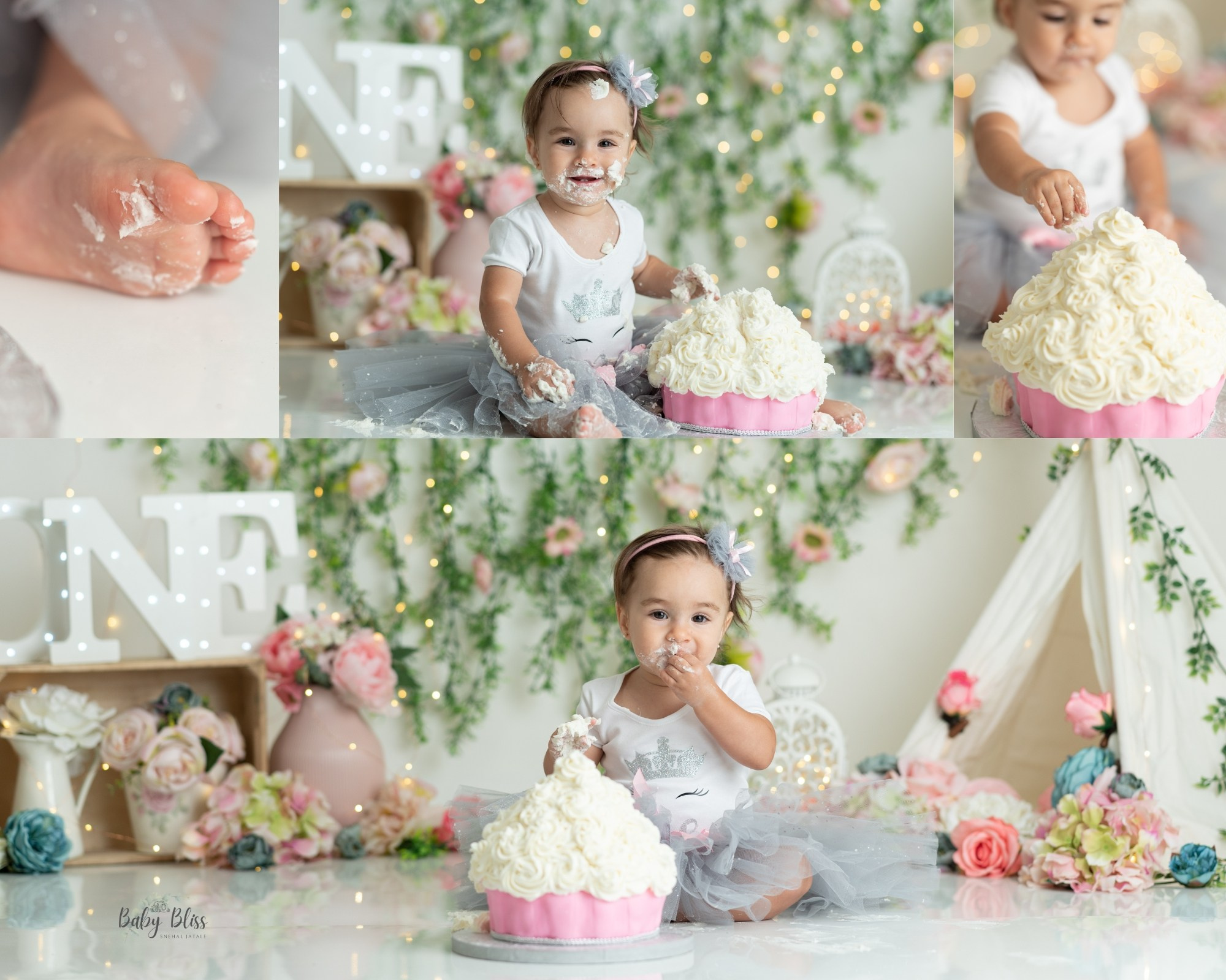 one year old baby girl having pink cake, with boho greenery theam in the background with little tent setup.