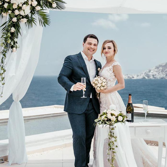 Молодожены в свадебной арке высоко над морем на Крите. Фотограф в Греции Екатерина Романова, свадьба.