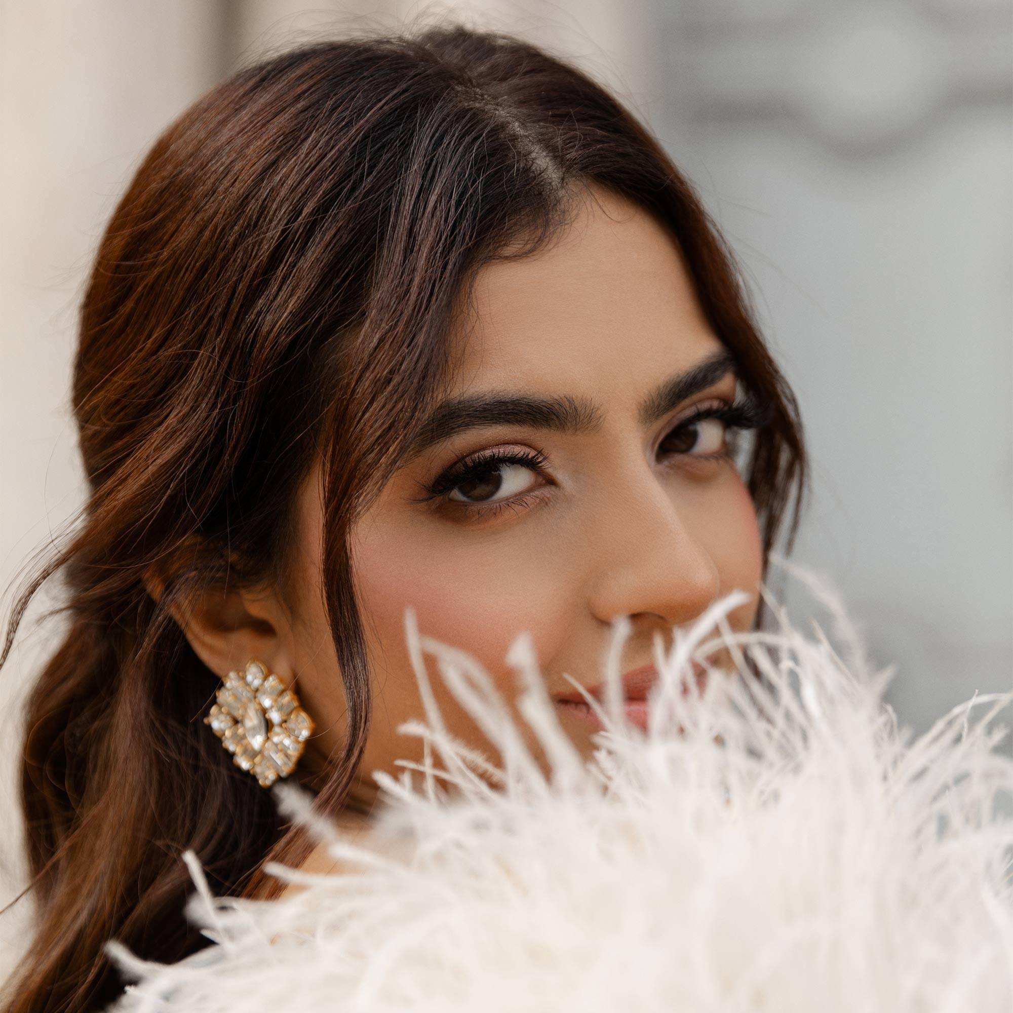a smiling girl with brown eyeliner makeup and red lips in red coat with a coffee cup in hands in a bar in the center of rome