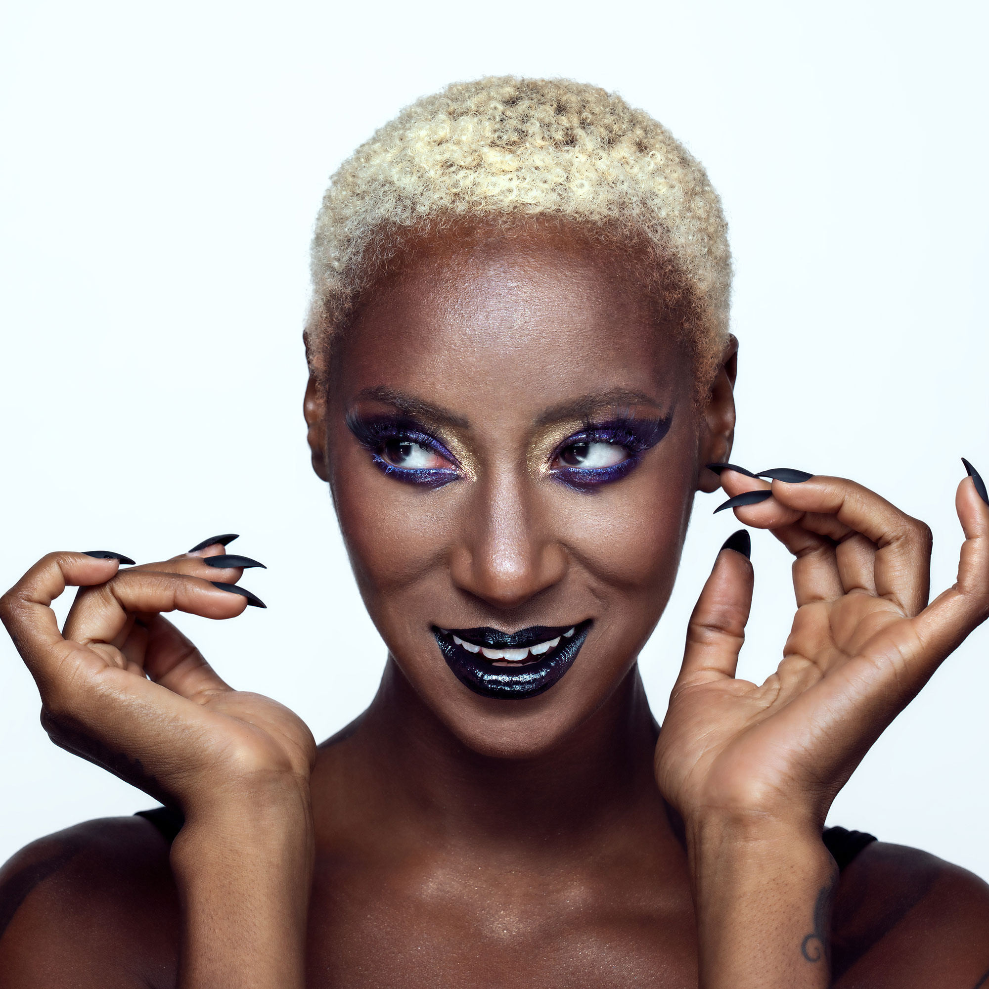 artistic bold glossy makeup on black-skinned woman with white hair