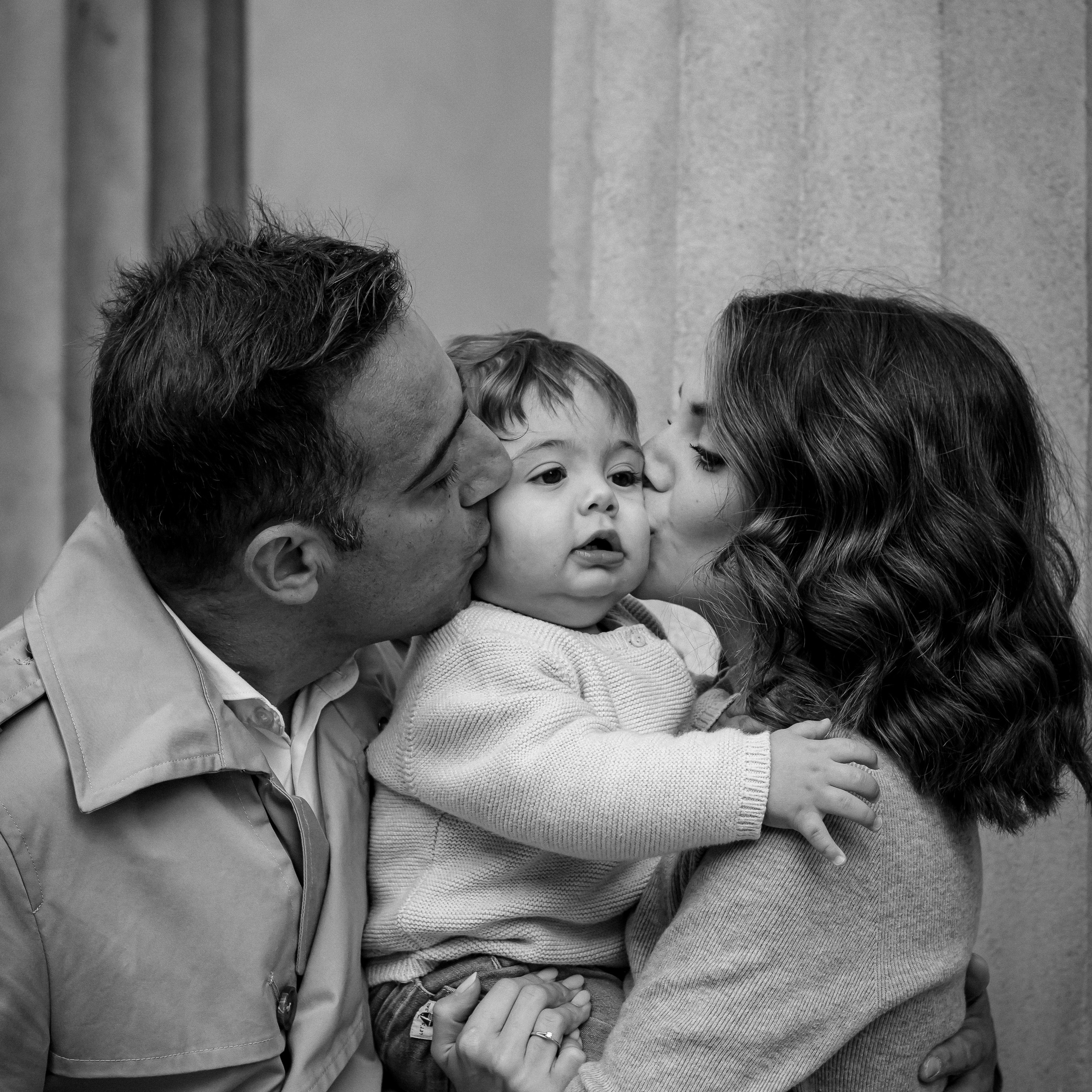 Черно-белая фотография родители обнимают ребенка . Фотограф семья фотосессия в Милане и провинции.