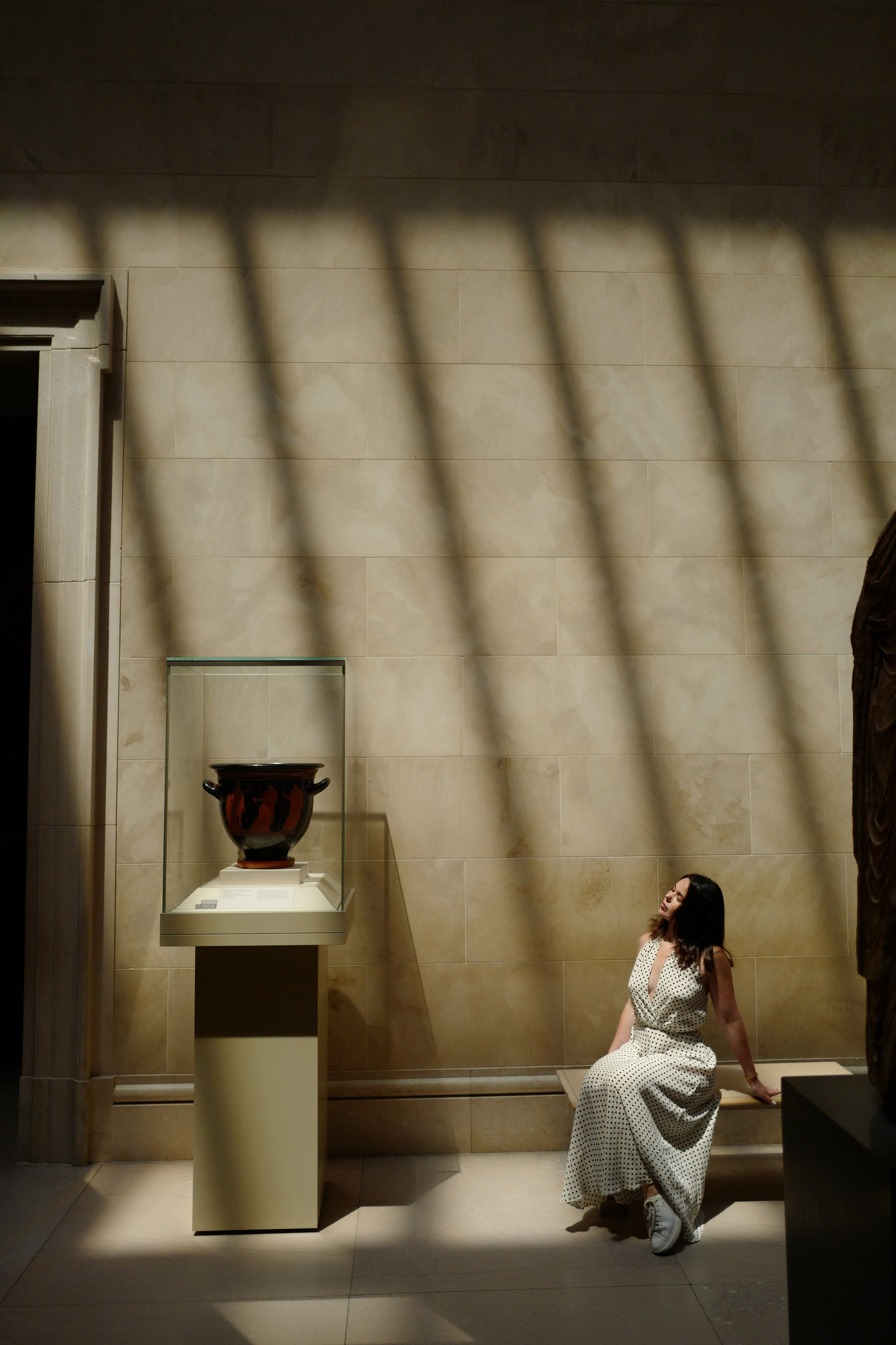 a woman sitting on the ground in a museum