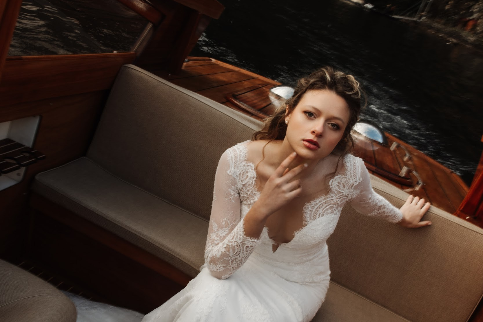 Bride on wooden boat at Lake Como during elegant Italian wedding