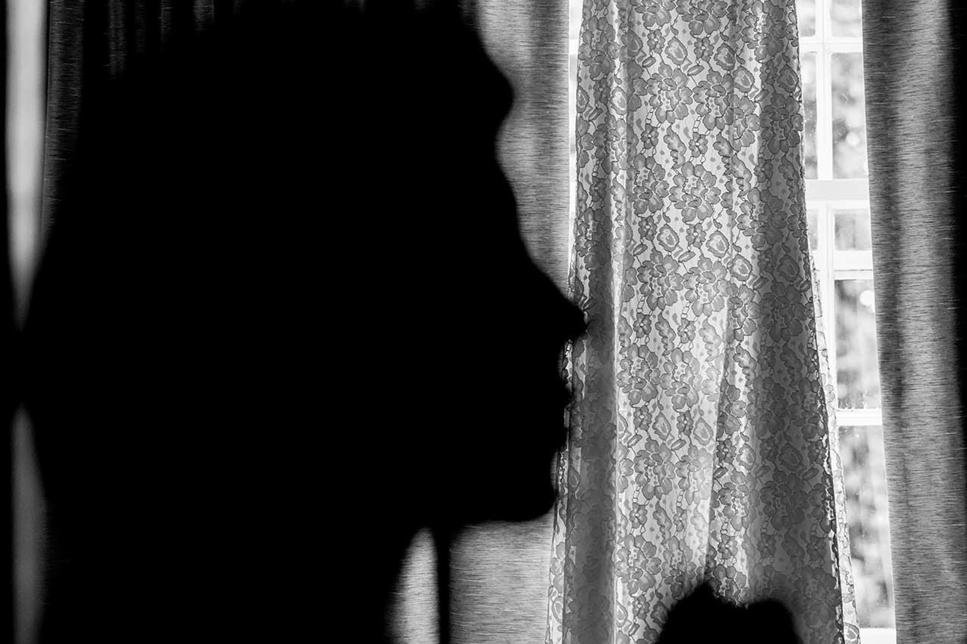 Wedding photographer Royal Berkshire, Ascot UK Bride puttin on her makeup, bridal dress in background Nikon D850