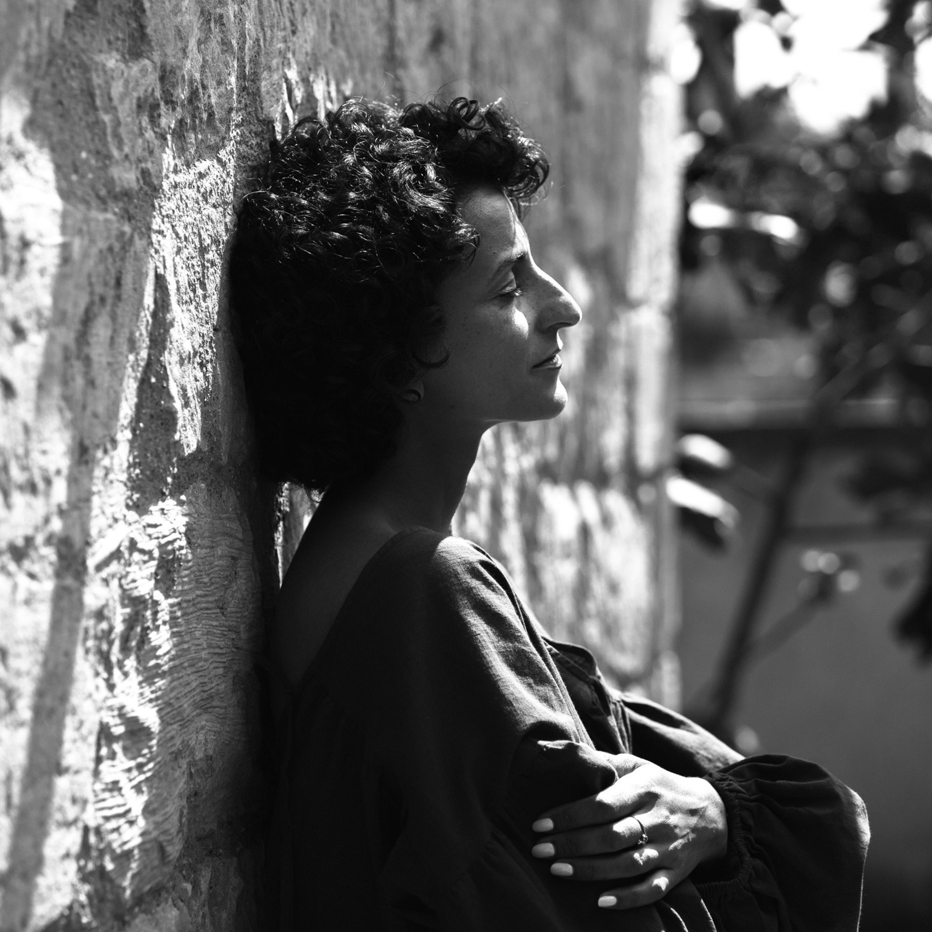 Schwarzweiß-Portrait einer Frau an einer Steinwand