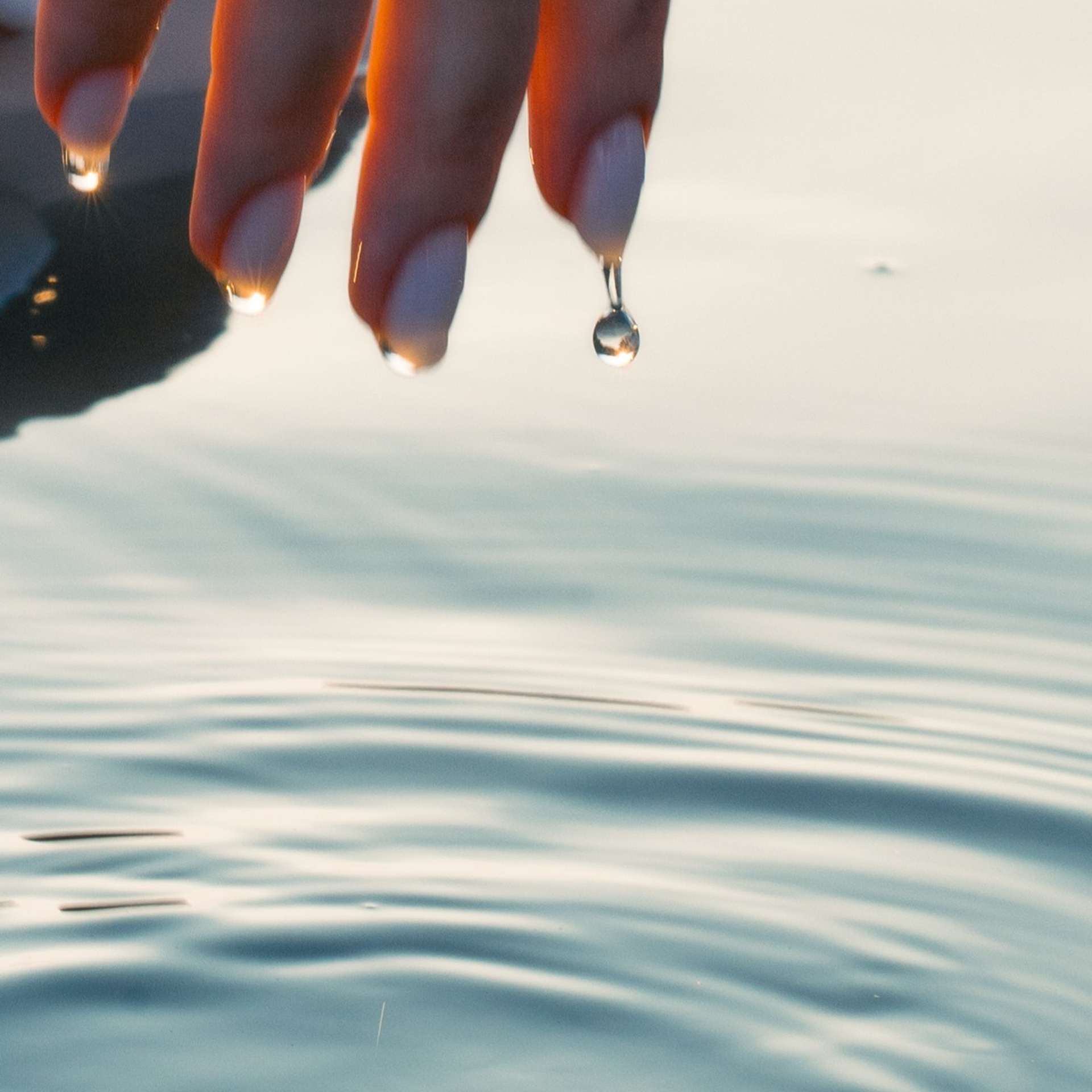 Künstlerisches Detailportrait – Hand mit Wassertropfen