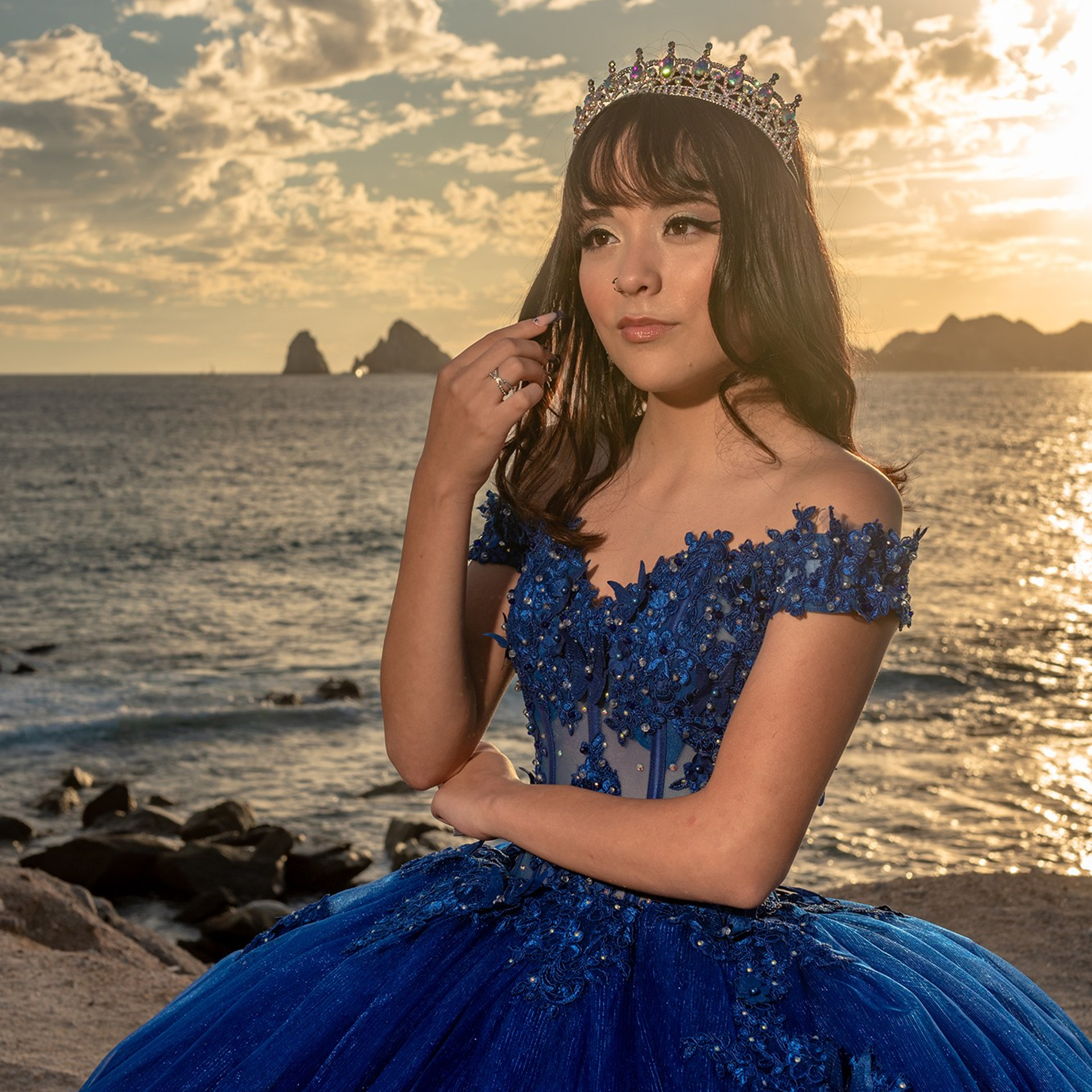 XV años photoshoot in Cabo – Quinceañera Michelle posing in blue embroidered dress with colorful bouquet, portrait photography for sweet fifteen celebrations in Los Cabos at the beach during sunset