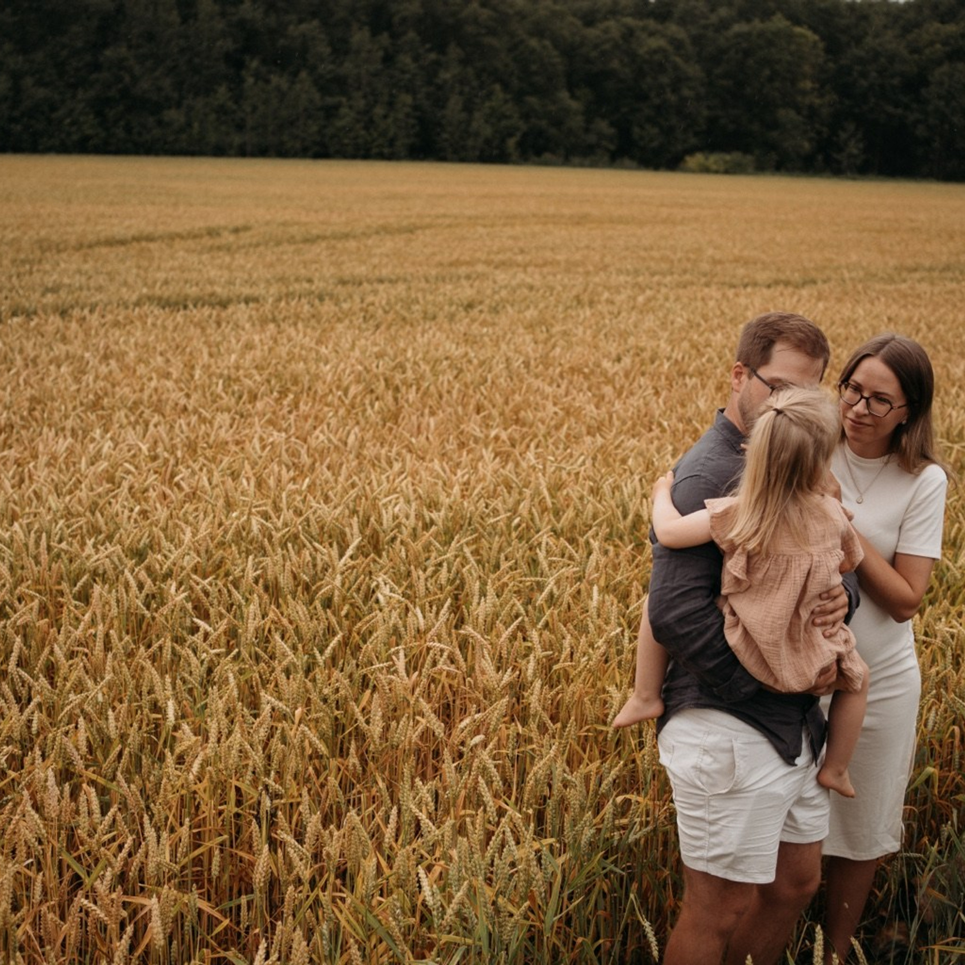 A family embracing in a golden field, photographed by Ivan Boglajev