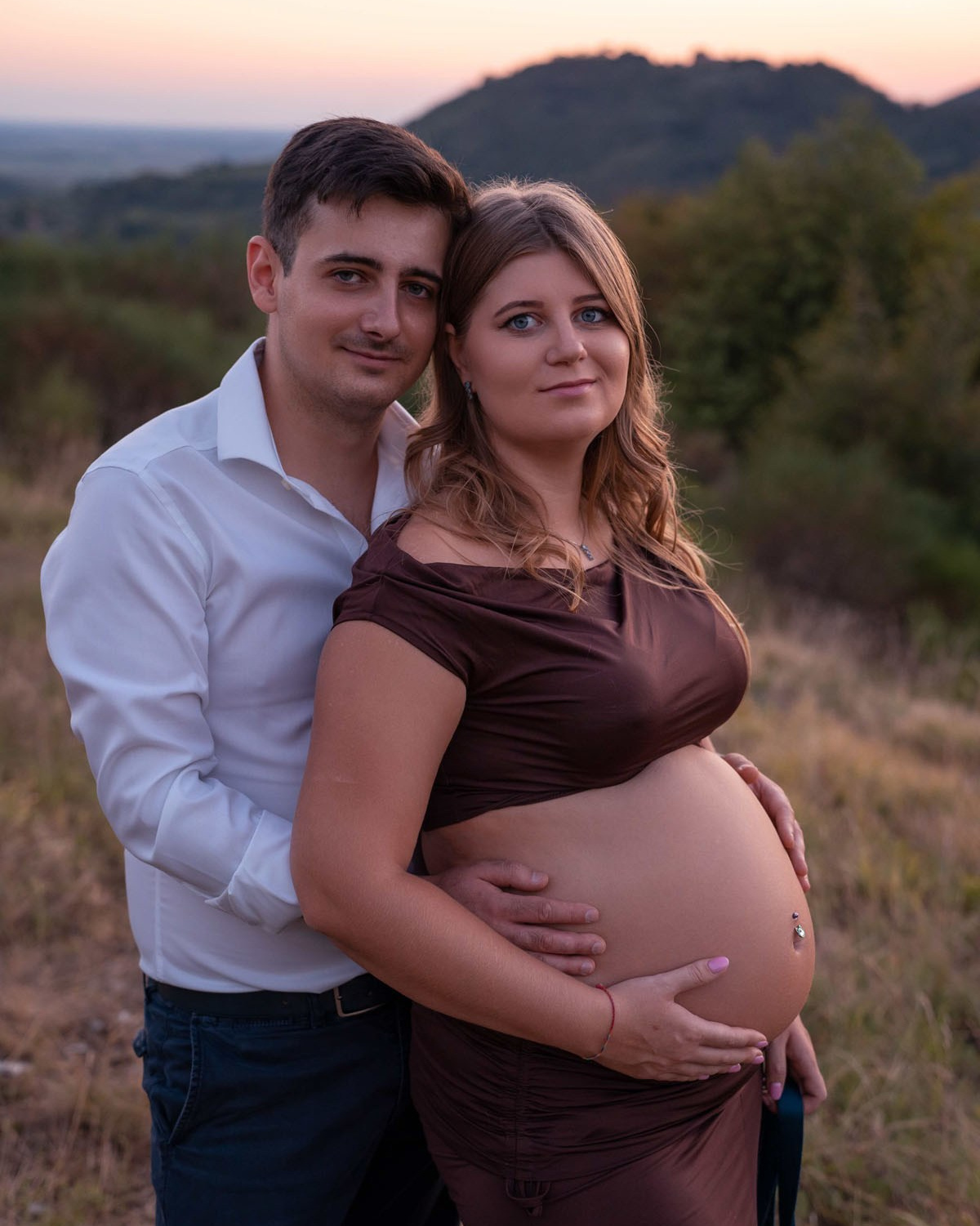 Futura mamma in abito elegante durante un servizio fotografico gravidanza all'aperto