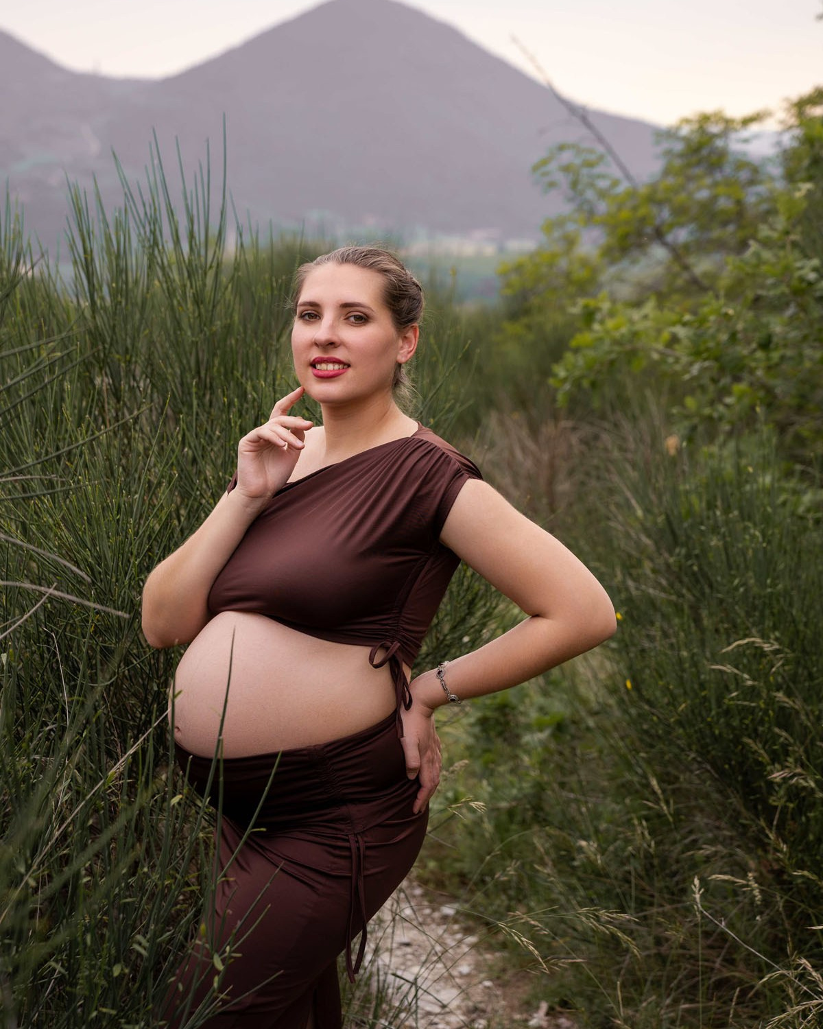 Futura mamma in abito elegante durante un servizio fotografico gravidanza all'aperto