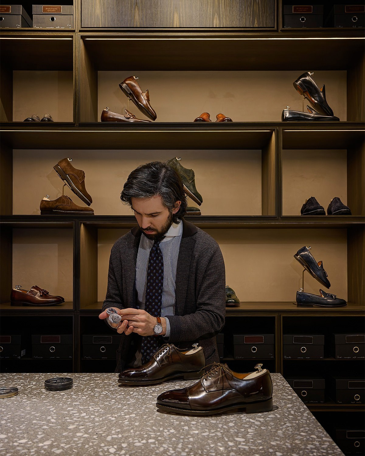 Business- und Produktfotografie Wien – Verkäufer präsentiert Lederschuhe in exklusivem Geschäft.