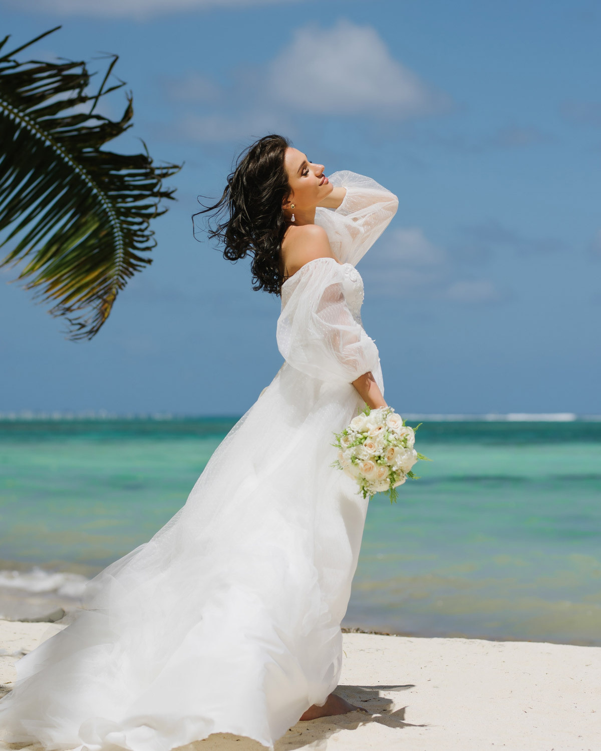 Невеста прикрывает глаза от яркого Доминиканского солнца.