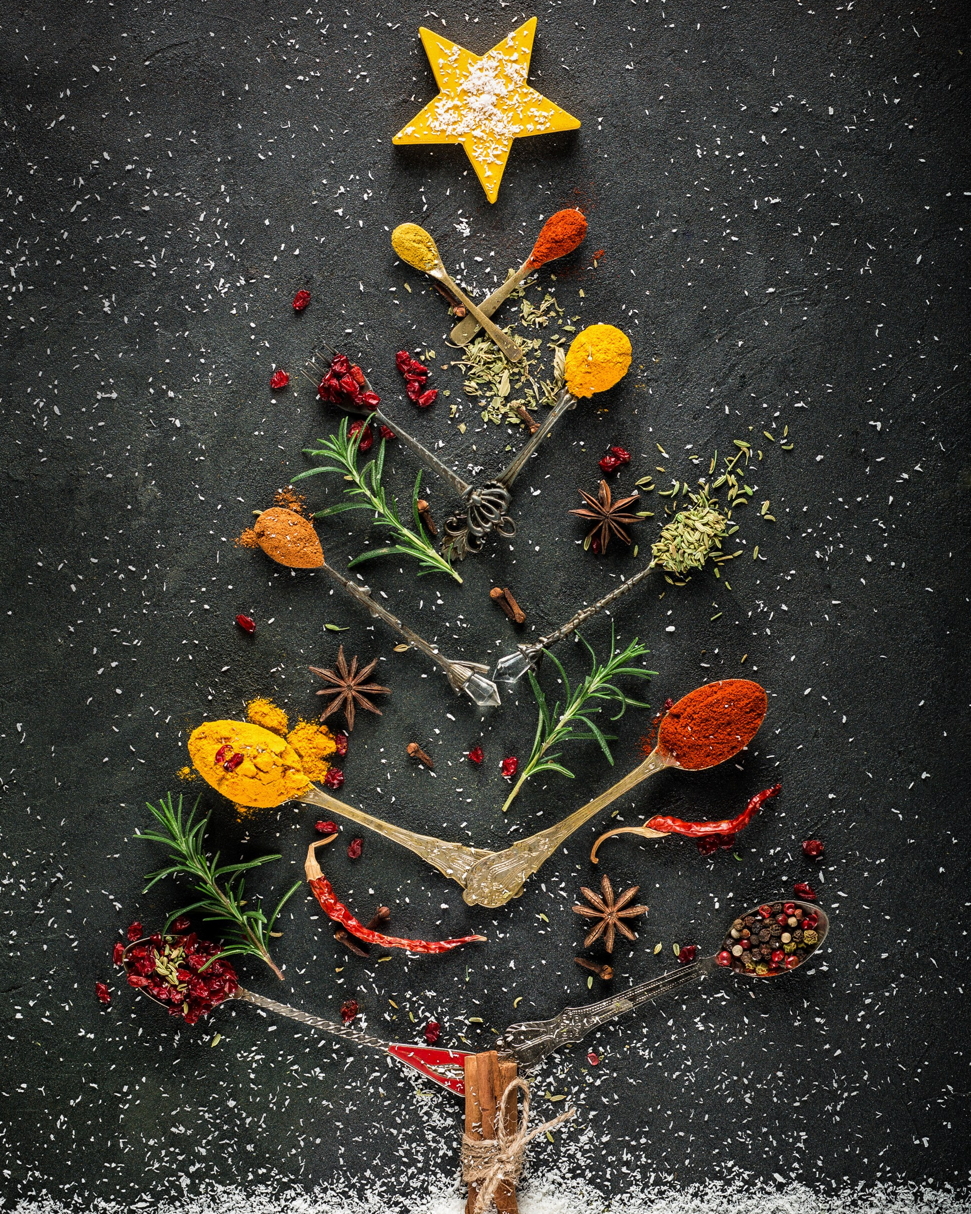 Tünd, qara fon üzərində müxtəlif ədviyyatlardan (darçın, bibər, zəncəfil, rozmarin və s.) və kiçik gümüşü qaşıqlardan yaradılmış Milad ağacı kompozisiyası. Ən üstdə sarı, ulduz formalı ədviyyat parçası, ağacın altında isə süni qar yığını var.