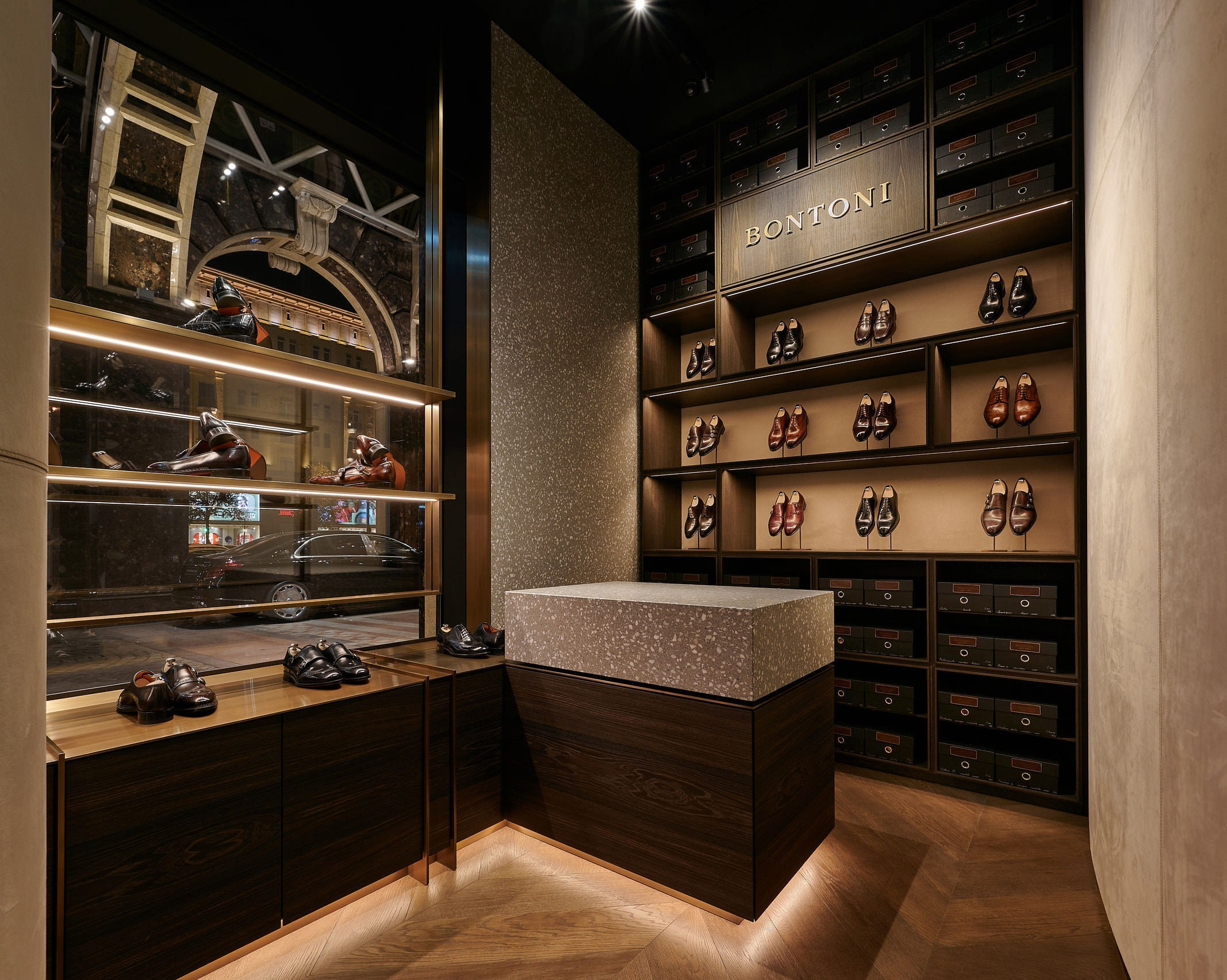 Interieurfotografie Wien – Luxus Schuhladen mit Holzregalen und stilvoller Beleuchtung.