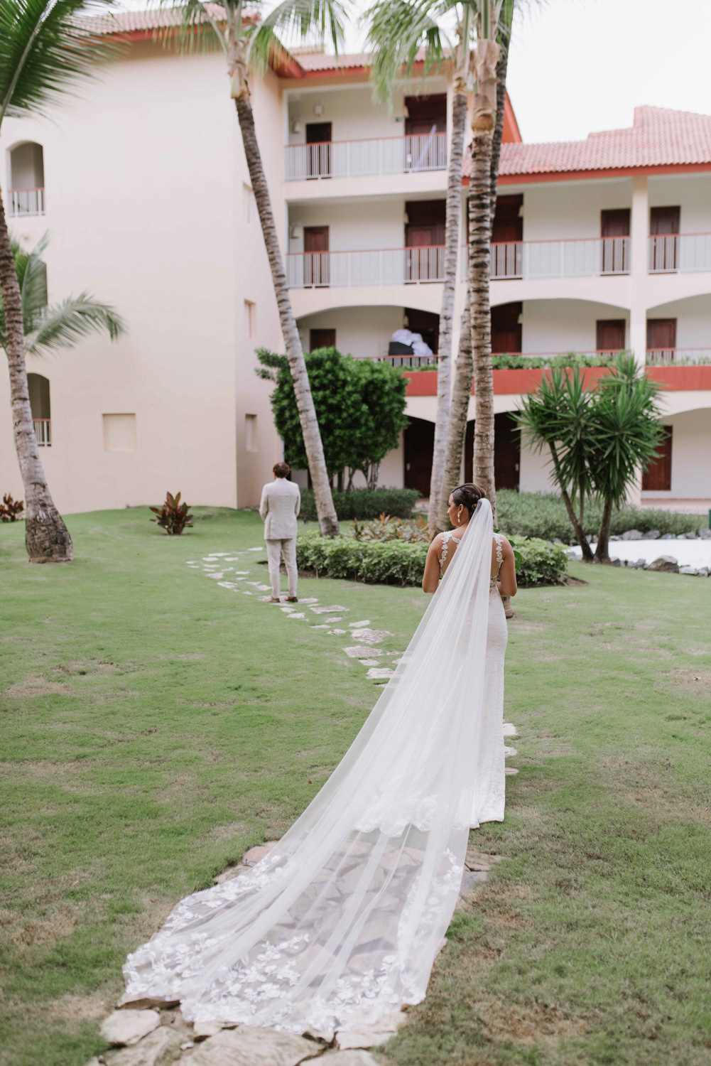 The bride with a long veil goes to the groom. 