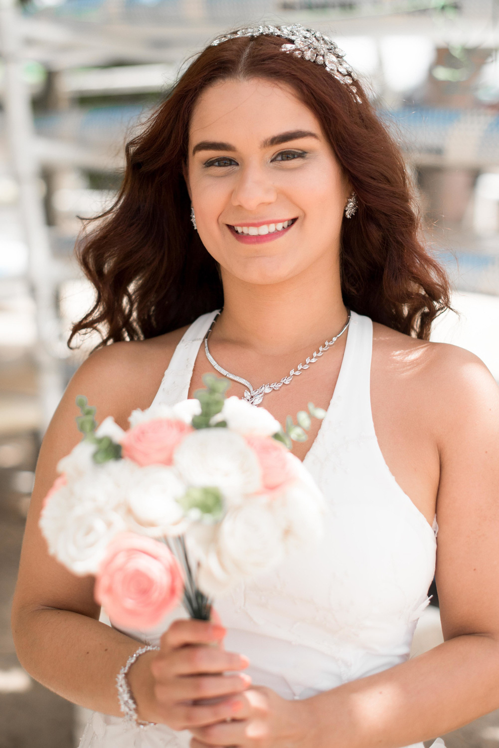 Невеста улыбается на фотографии, в руках у нее букет цветов.
